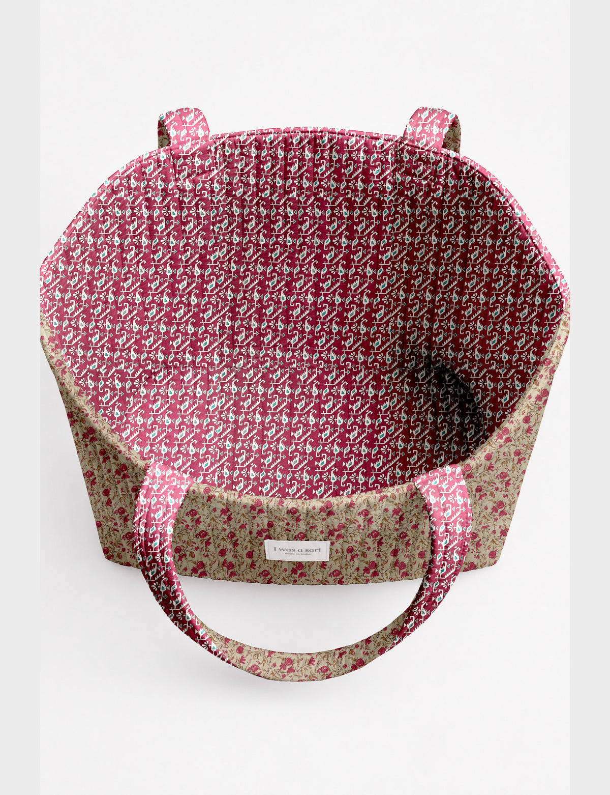 Quilted beach bag with yellow tropical exterior and red patterned interior, shown from top view with handles visible