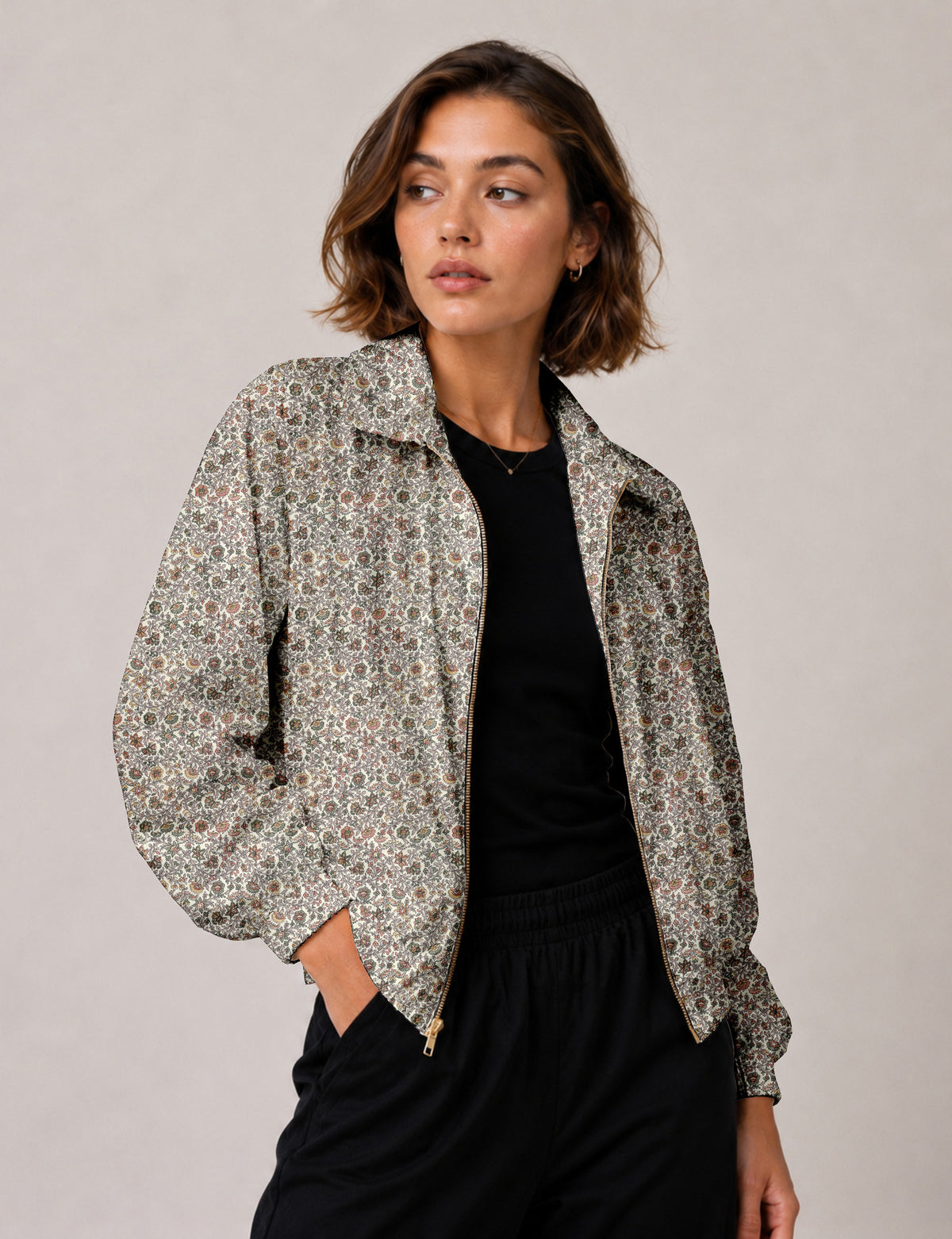 Brown floral bomber jacket with front zipper, elastic cuffs and hem, hanging on white hanger, red floral inner lining visible