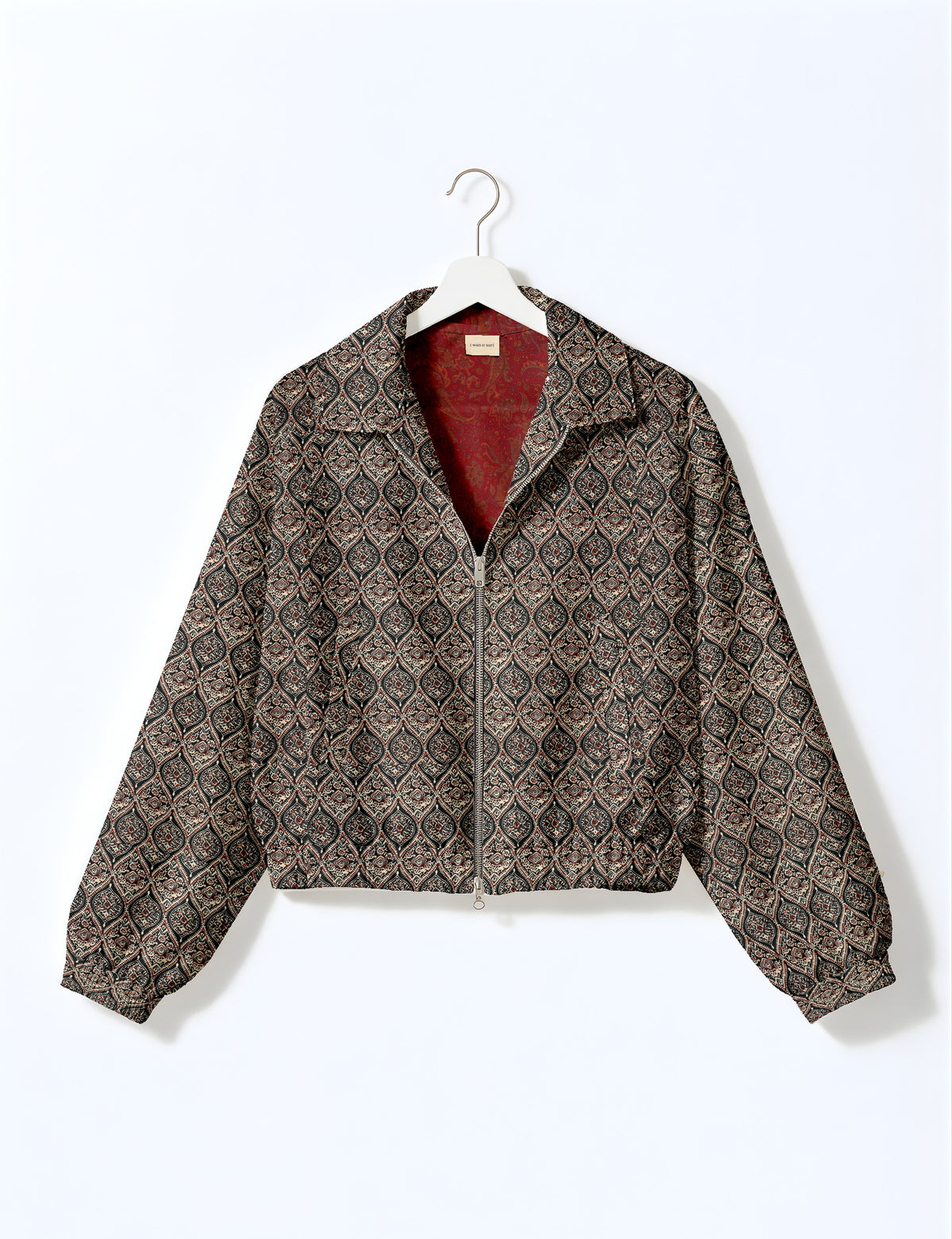 Brown floral bomber jacket with front zipper, elastic cuffs and hem, hanging on white hanger, red floral inner lining visible