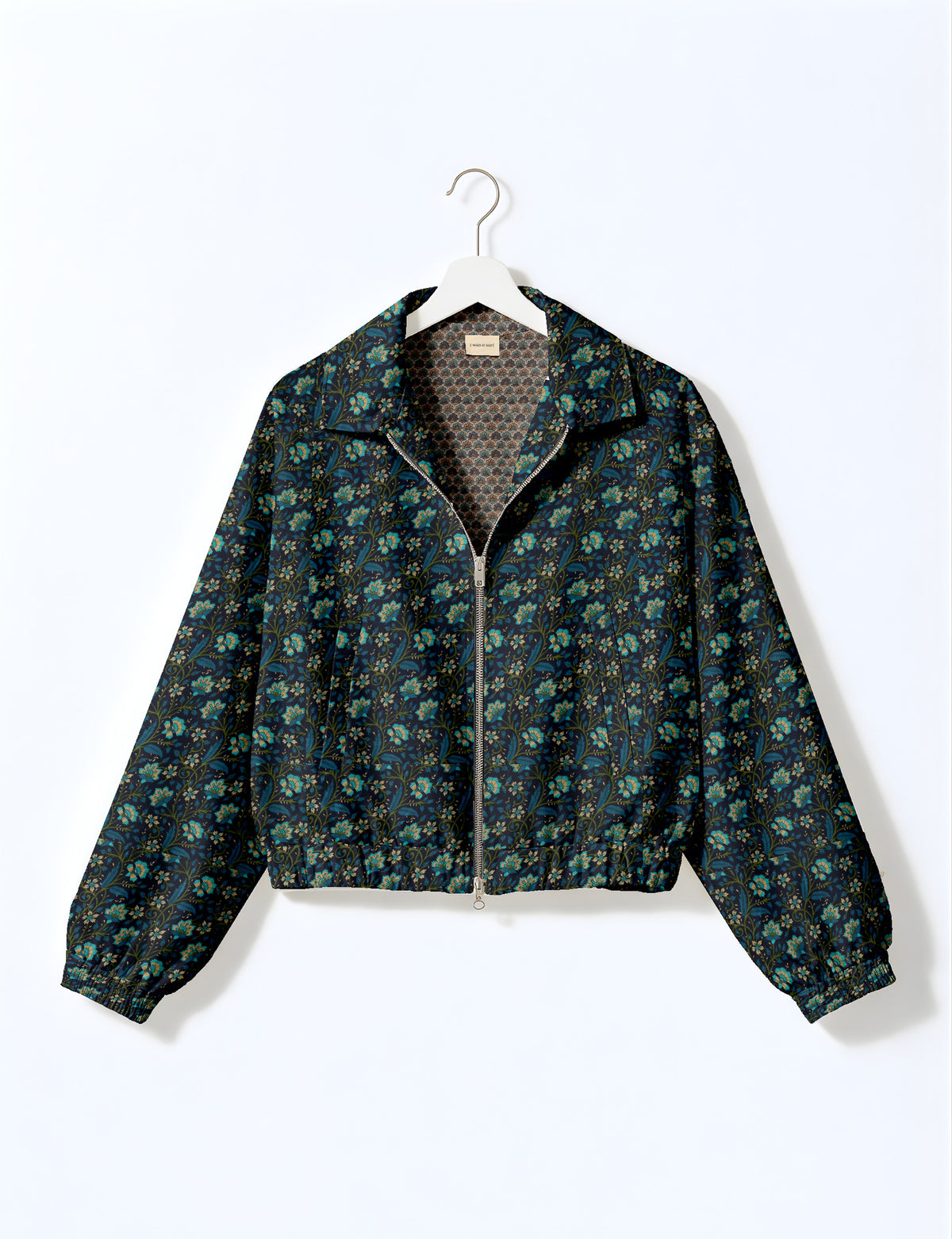 Brown floral bomber jacket with front zipper, elastic cuffs and hem, hanging on white hanger, red floral inner lining visible