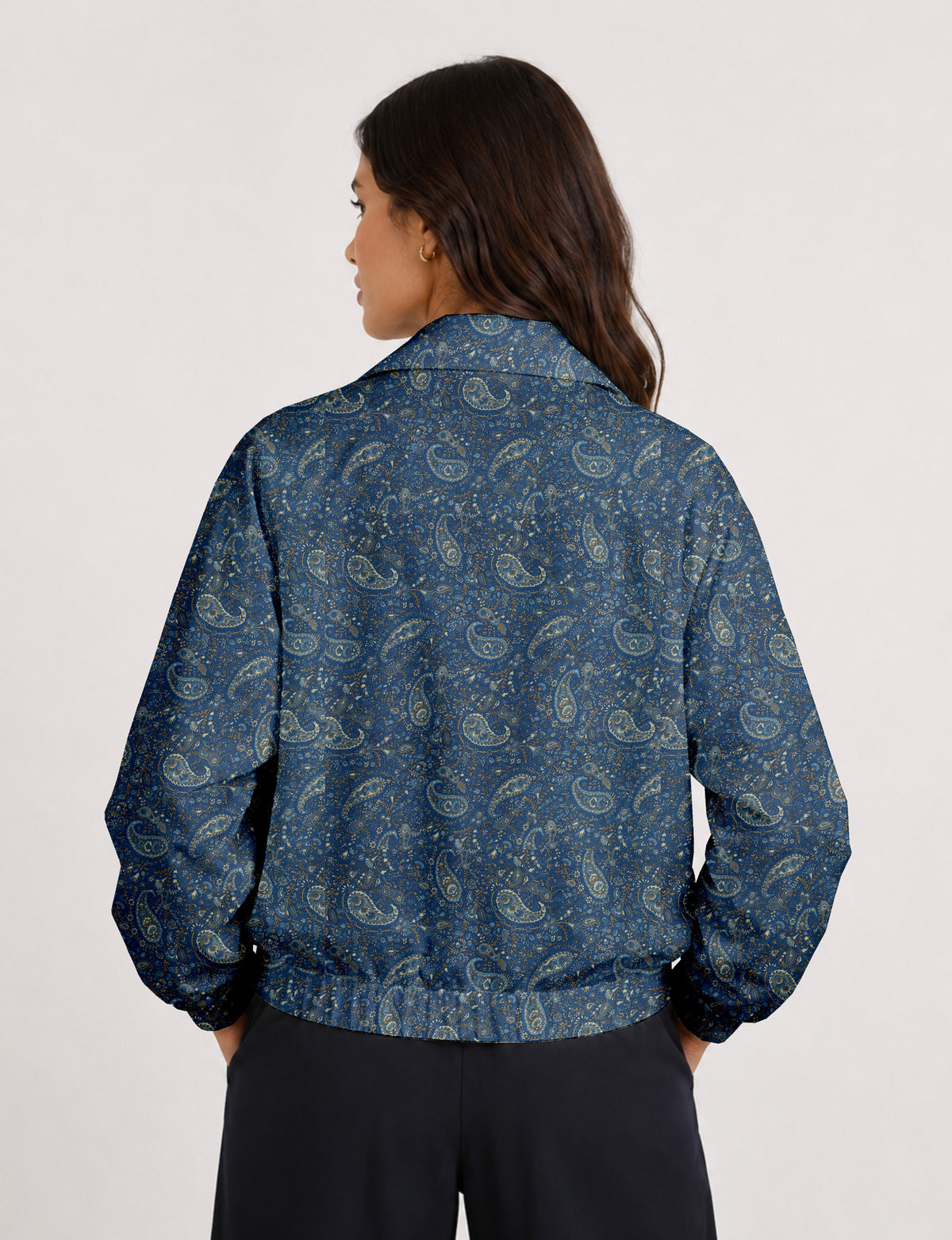 Woman wearing a yellow floral bomber jacket with front zipper, elastic cuffs, and side pockets, shown from front view