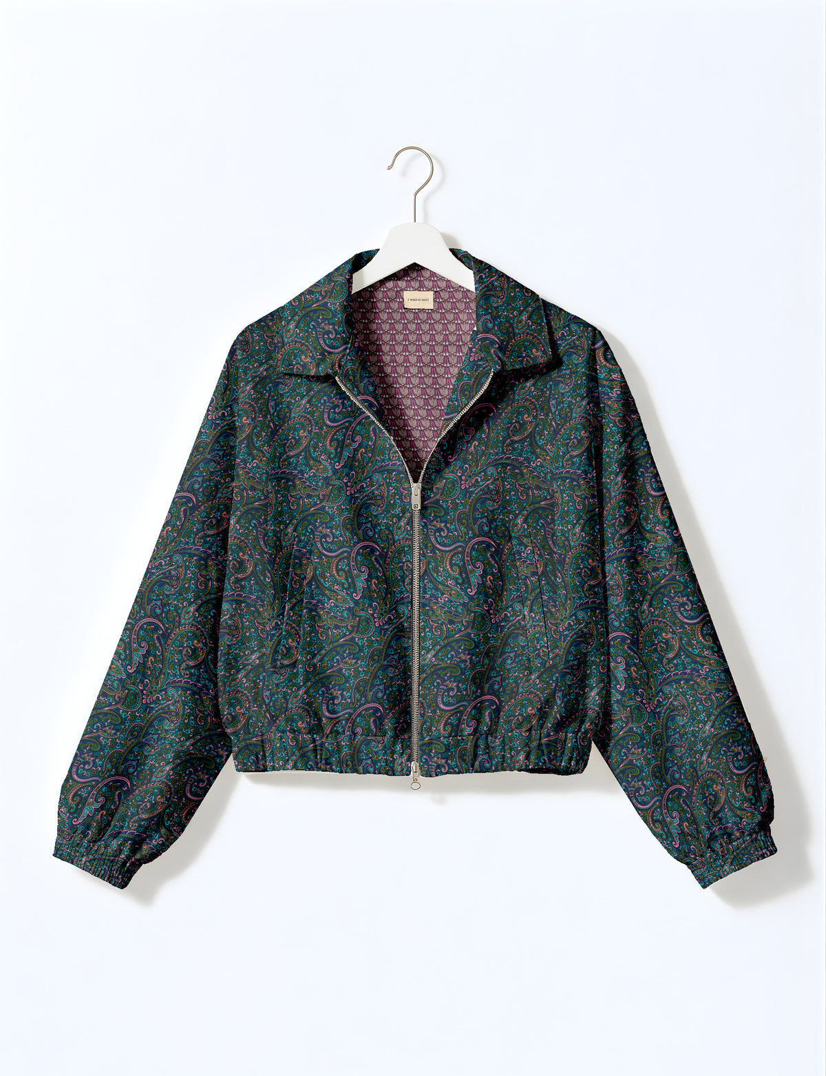 Brown floral bomber jacket with front zipper, elastic cuffs and hem, hanging on white hanger, red floral inner lining visible