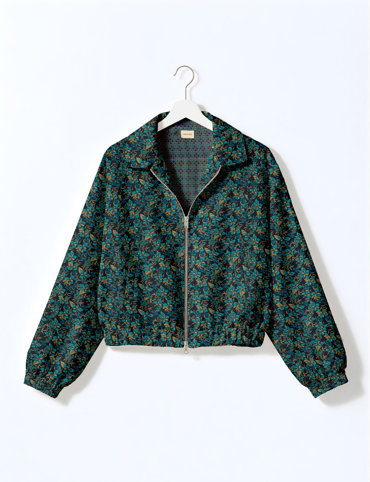 Brown floral bomber jacket with front zipper, elastic cuffs and hem, hanging on white hanger, red floral inner lining visible