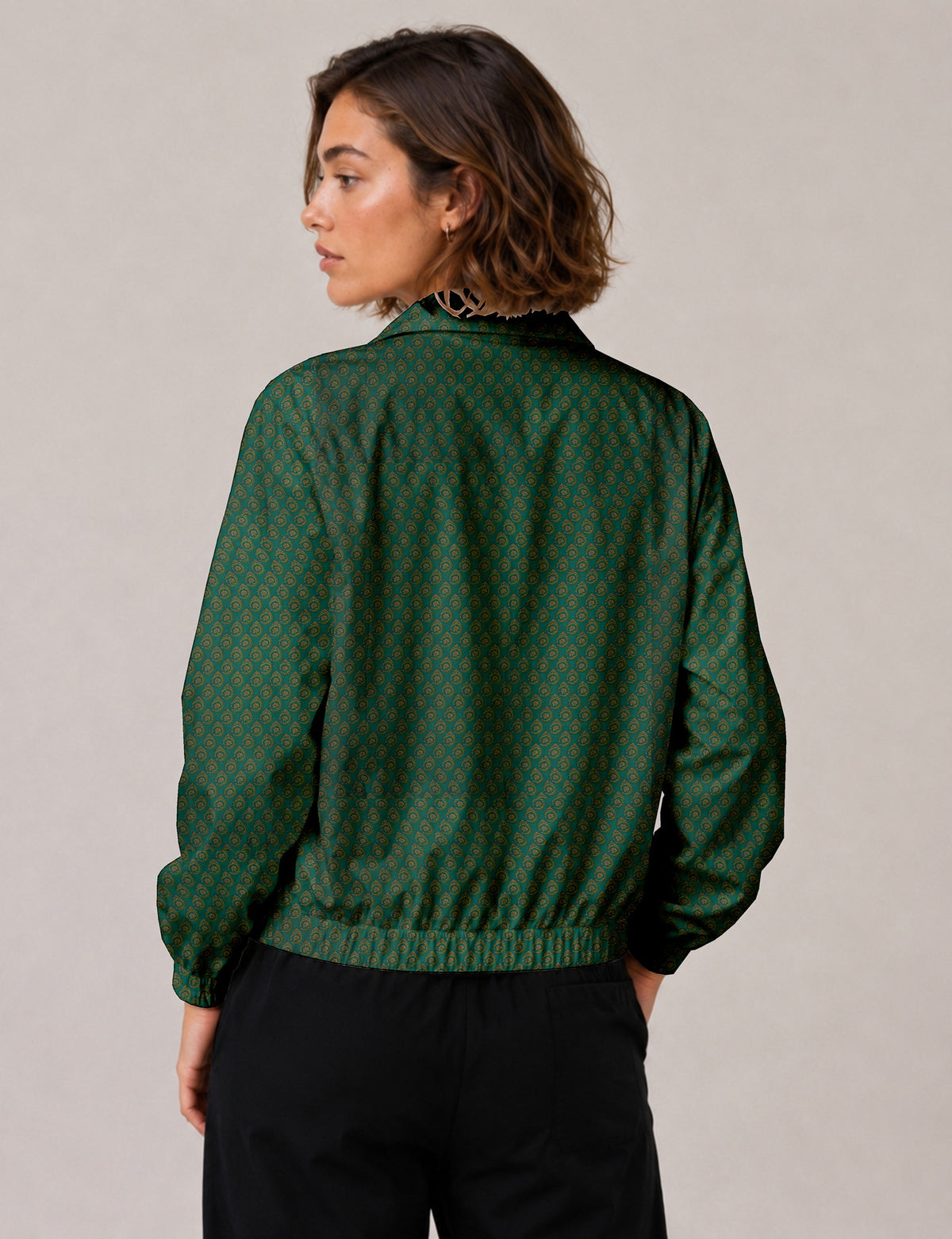 Woman wearing a yellow floral bomber jacket with front zipper, elastic cuffs, and side pockets, shown from front view