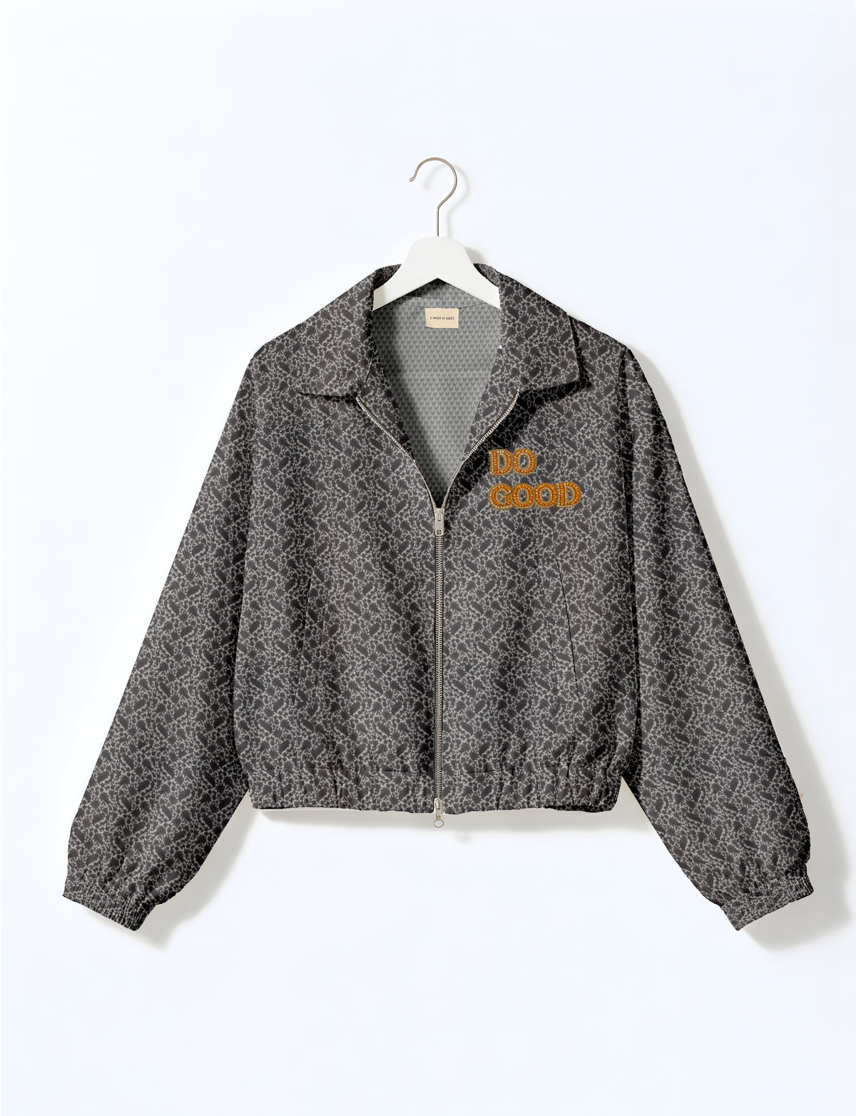 Gold cropped DO GOOD bomber jacket featuring hand-embroidered lettering on the left chest, contrasting inner lining and two functional pockets.