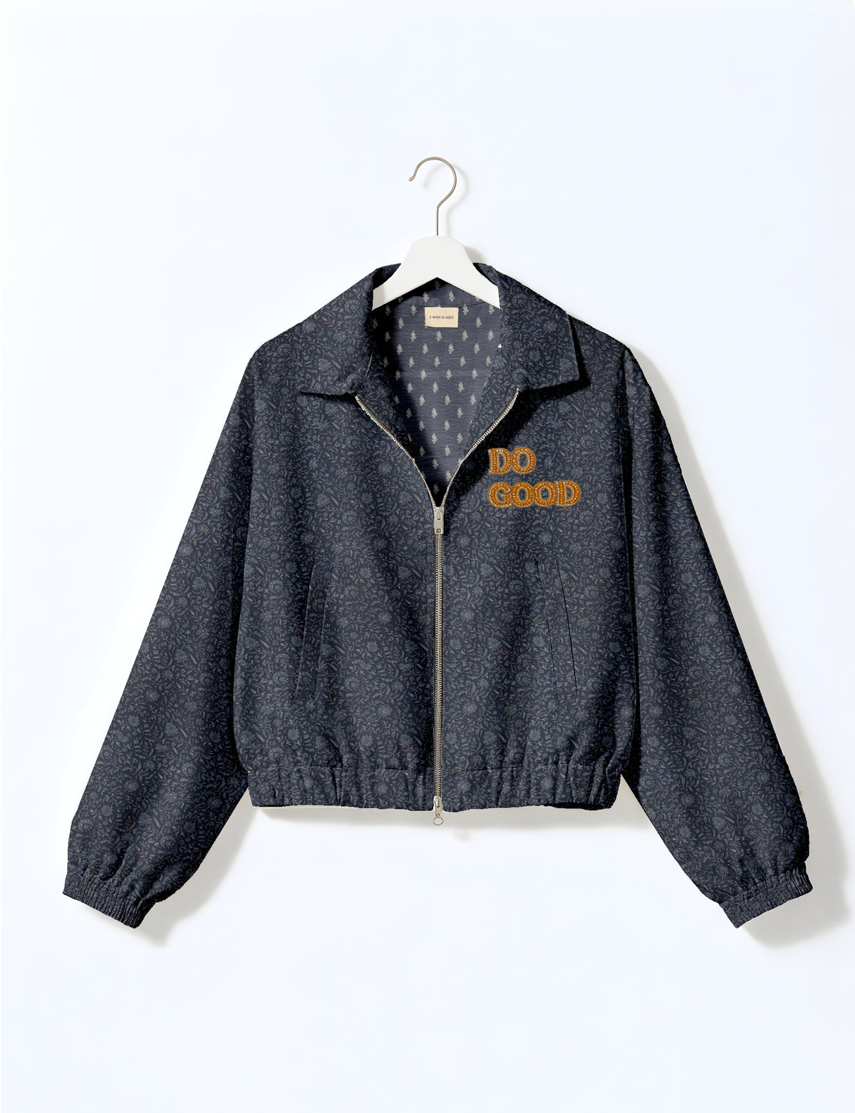 Gold cropped DO GOOD bomber jacket featuring hand-embroidered lettering on the left chest, contrasting inner lining and two functional pockets.