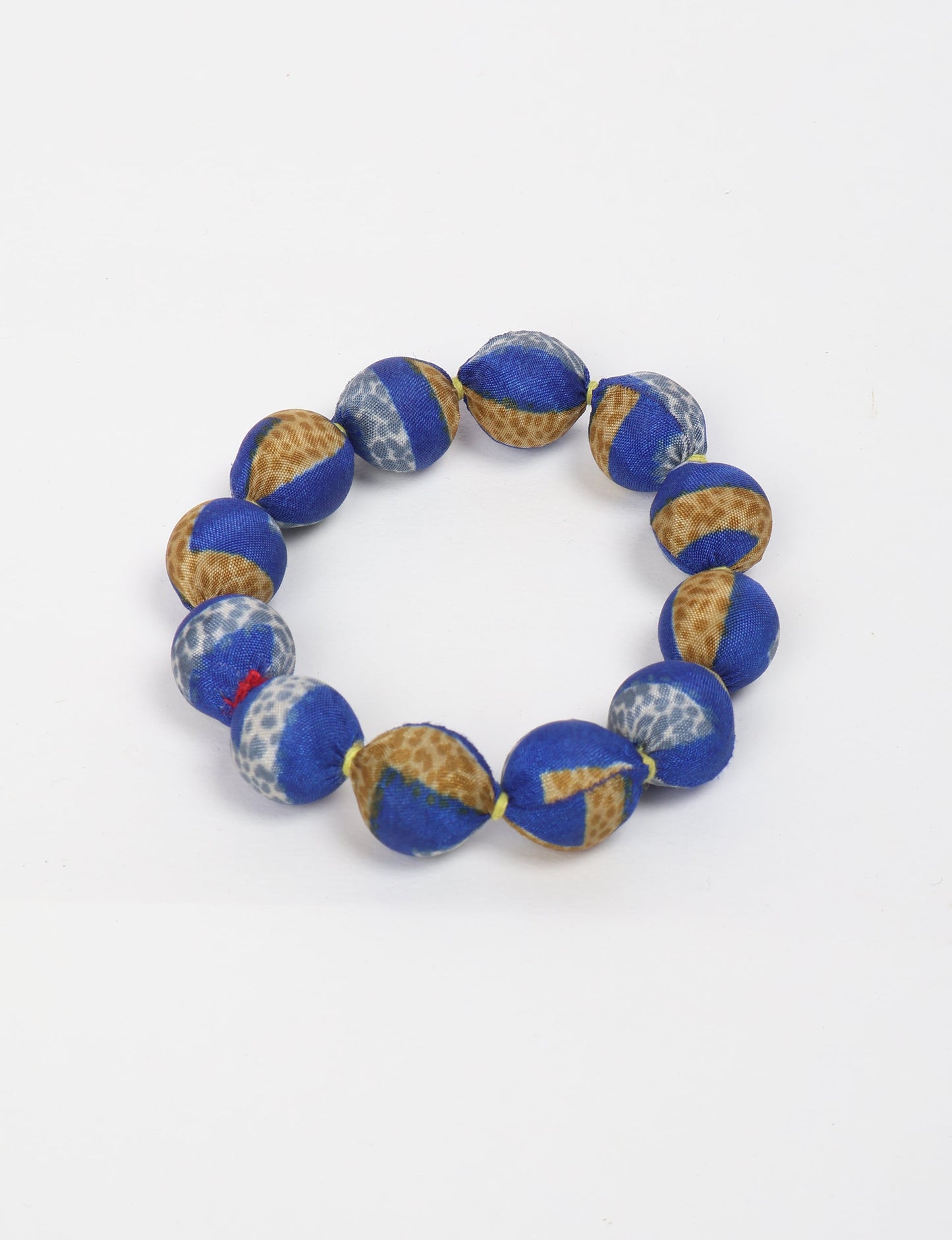 Eco friendly beaded knotted bracelet crafted from upcycled women’s clothing and repurposed sari fabrics, showcasing circular fashion and sustainable apparel.