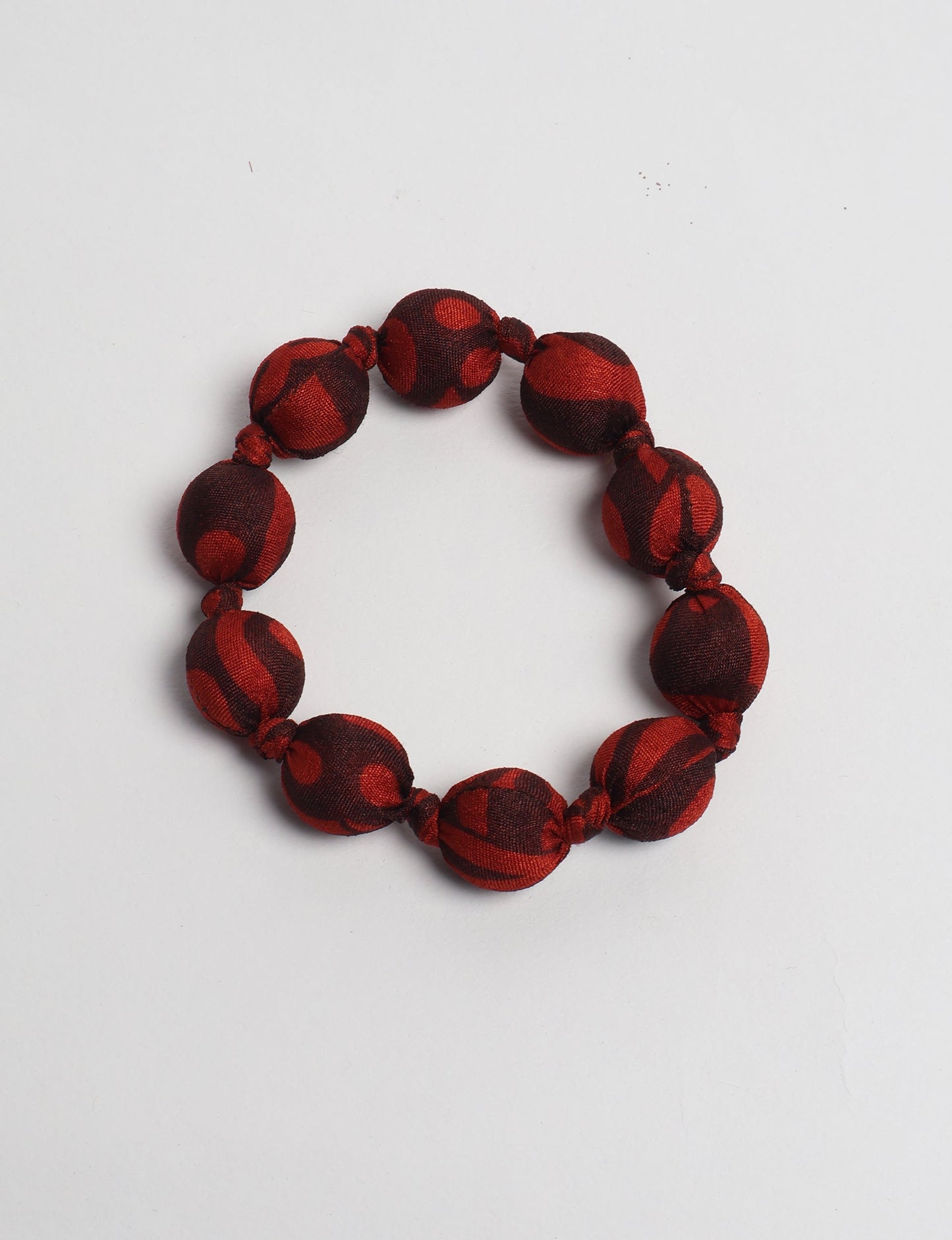 Eco friendly beaded knotted bracelet crafted from upcycled women’s clothing and repurposed sari fabrics, showcasing circular fashion and sustainable apparel.