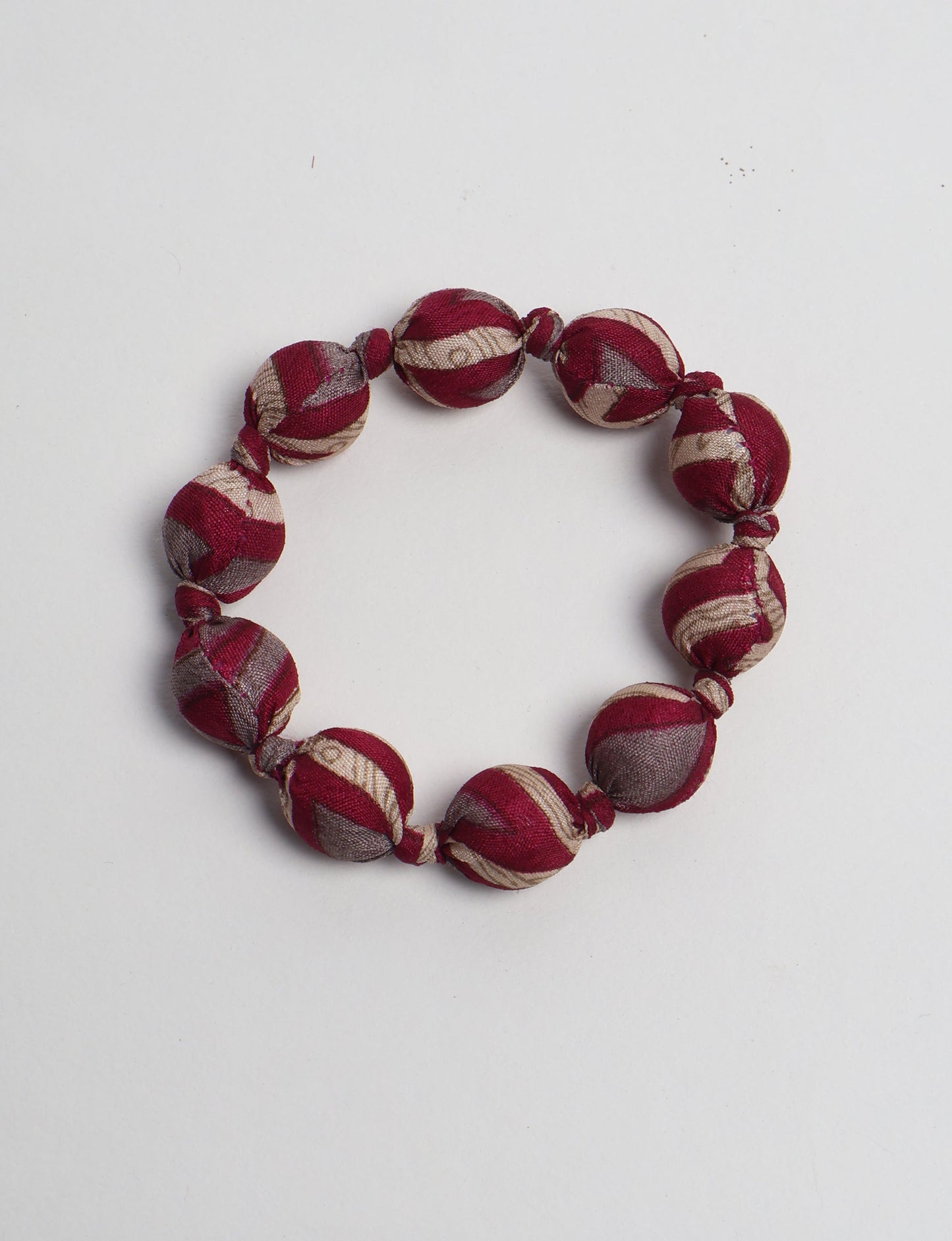 Eco friendly beaded knotted bracelet crafted from upcycled women’s clothing and repurposed sari fabrics, showcasing circular fashion and sustainable apparel.