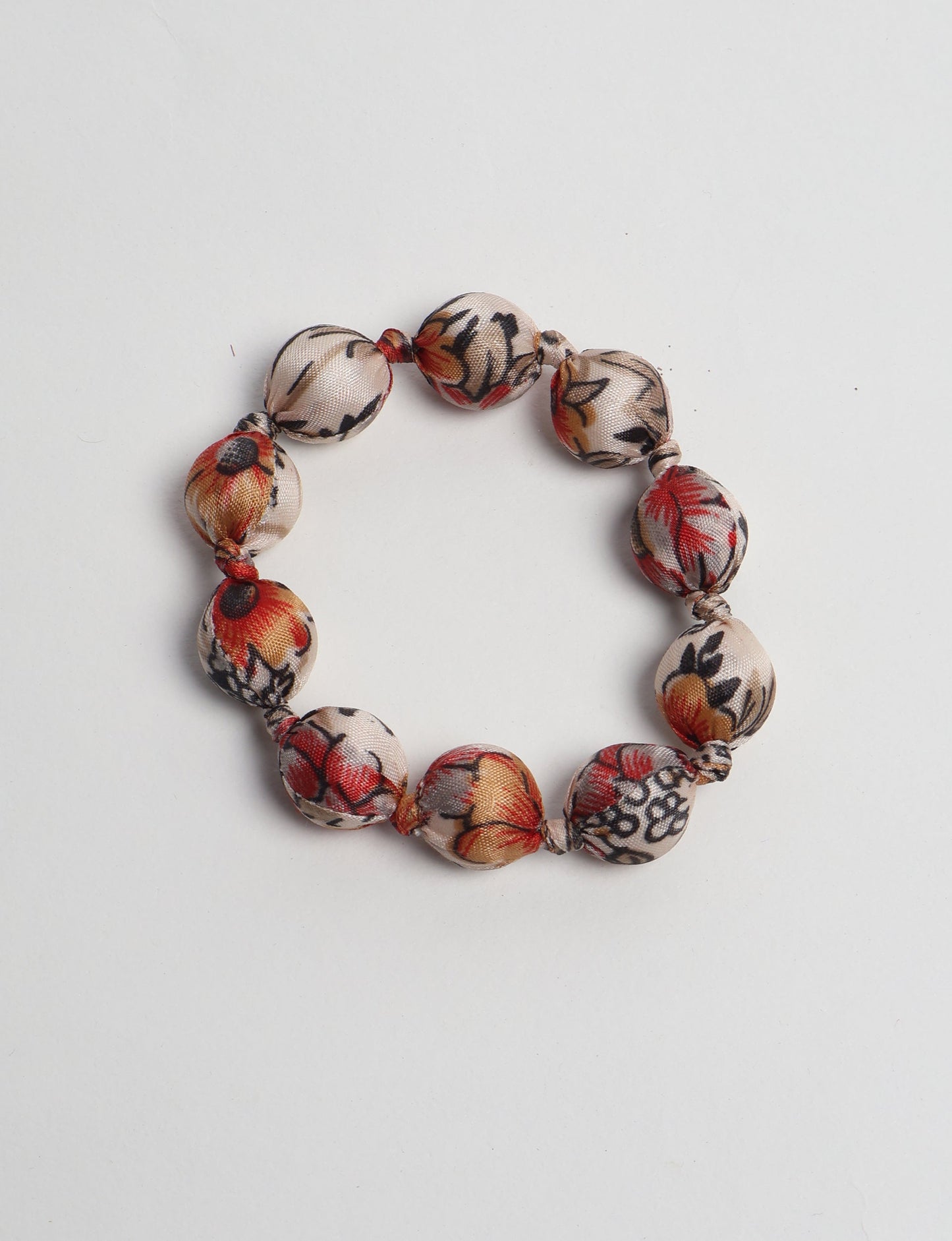 Eco friendly beaded knotted bracelet crafted from upcycled women’s clothing and repurposed sari fabrics, showcasing circular fashion and sustainable apparel.