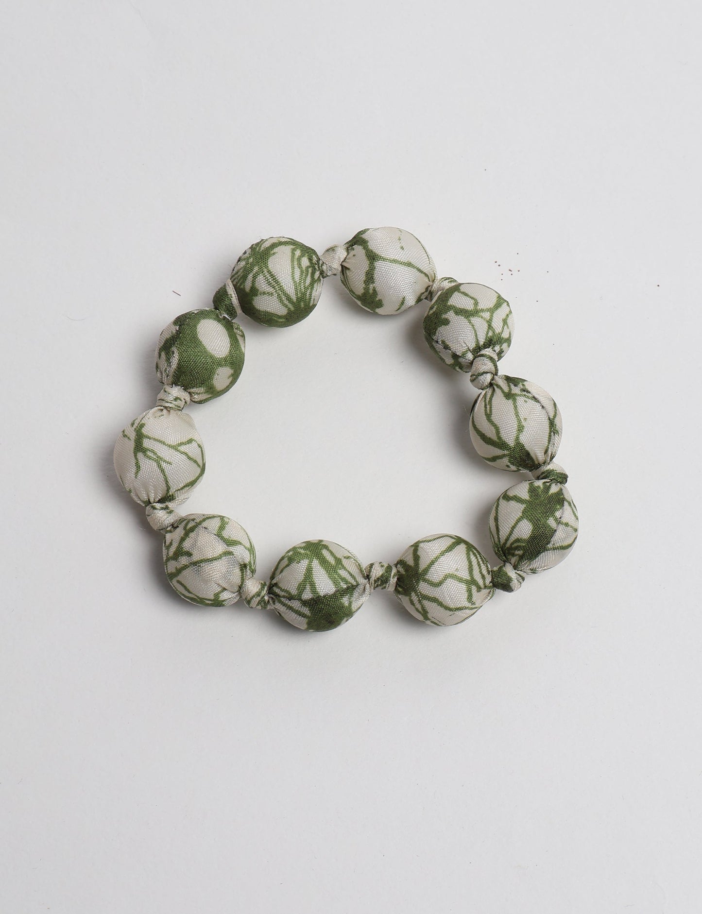Eco friendly beaded knotted bracelet crafted from upcycled women’s clothing and repurposed sari fabrics, showcasing circular fashion and sustainable apparel.