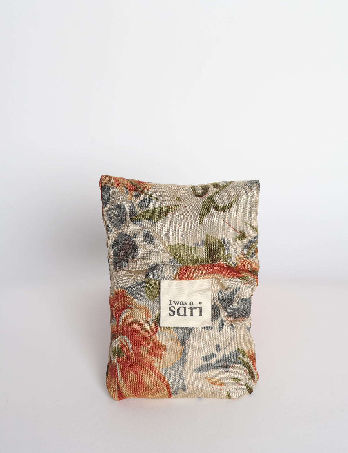 Blue reusable bag with multicolor tropical floral pattern folded with "I was a sari" label visible on front