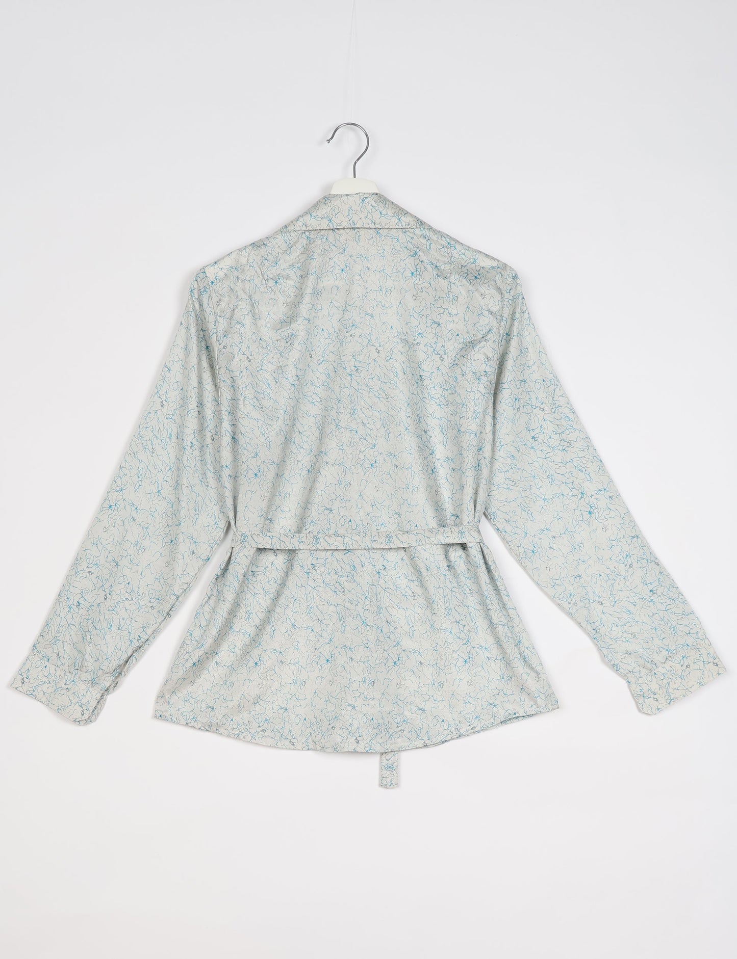 Experience sustainable fashion with our classic slim-fit shirt, crafted with ethical and green values. The shirt, designed for minimal waste, features a tie-up waist belt or neck tie, semi-spread collar, and regular shirt cuffs. Versatile and eco-friendly, wear it tucked in, unbuttoned over a tank top, or knotted at the waist for a unique style.