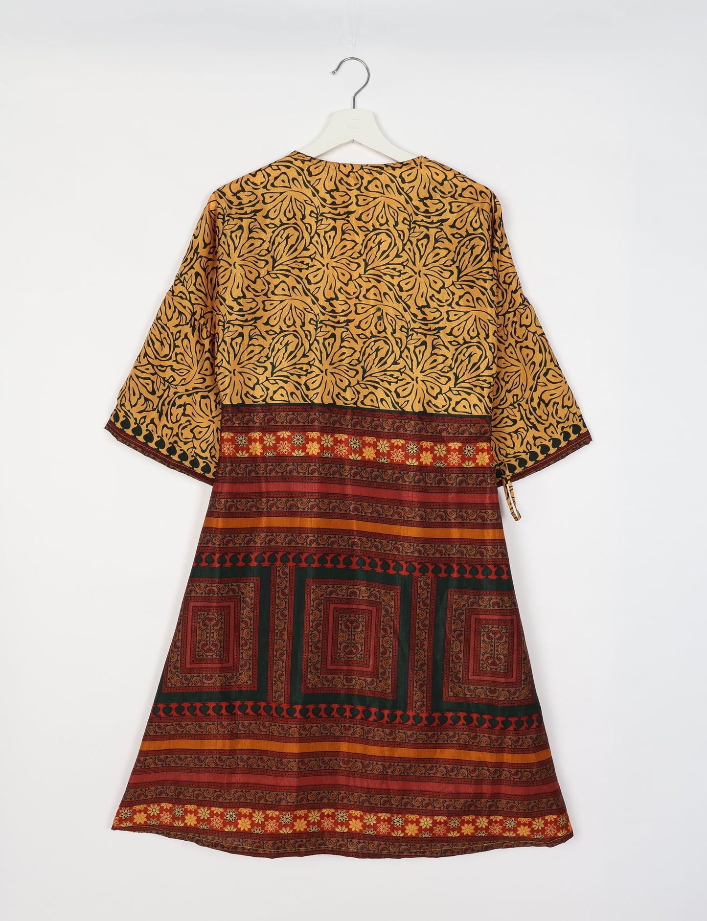 Elevate your style with our Sunset Coat, a shin-length wrap featuring a deep V-neck, wide flared 3/4 sleeves, and side tie with thread tassels. Embrace ethical and sustainable fashion with this zero waste, upcycled garment. A perfect blend of elegance and whimsy for conscious clothing enthusiasts.