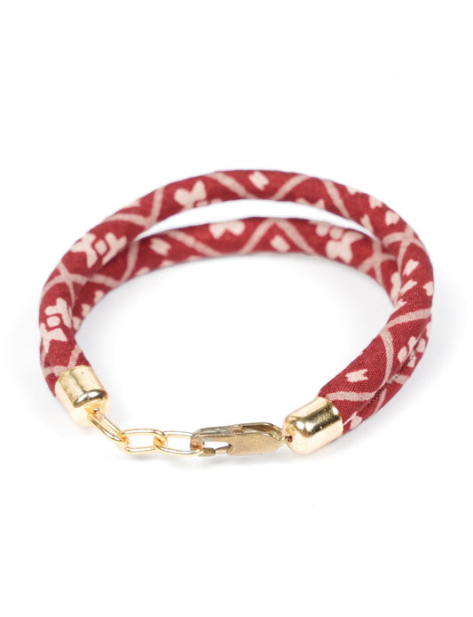 A close-up image of a hand wearing the Sari Rope bracelet, showcasing its colorful threads and unique design. This accessory embodies ethical fashion and sustainability, crafted from repurposed saris for a stylish and eco-conscious statement.