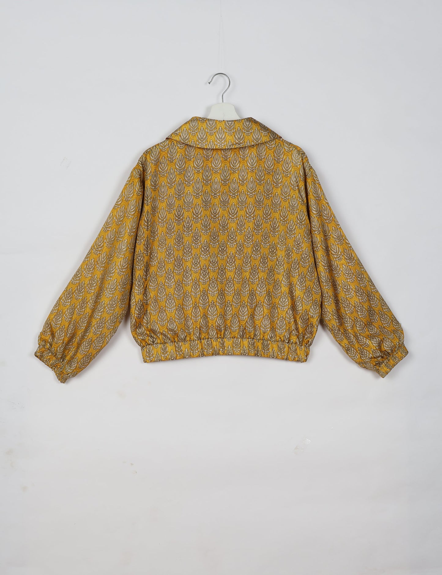 Stylish BOMBER JACKET, an upcycled clothing masterpiece with a cute cropped shape, elasticated details, and detachable metallic zipper. Contrast sari print lining adds a unique touch. Explore sustainable and eco-friendly fashion.