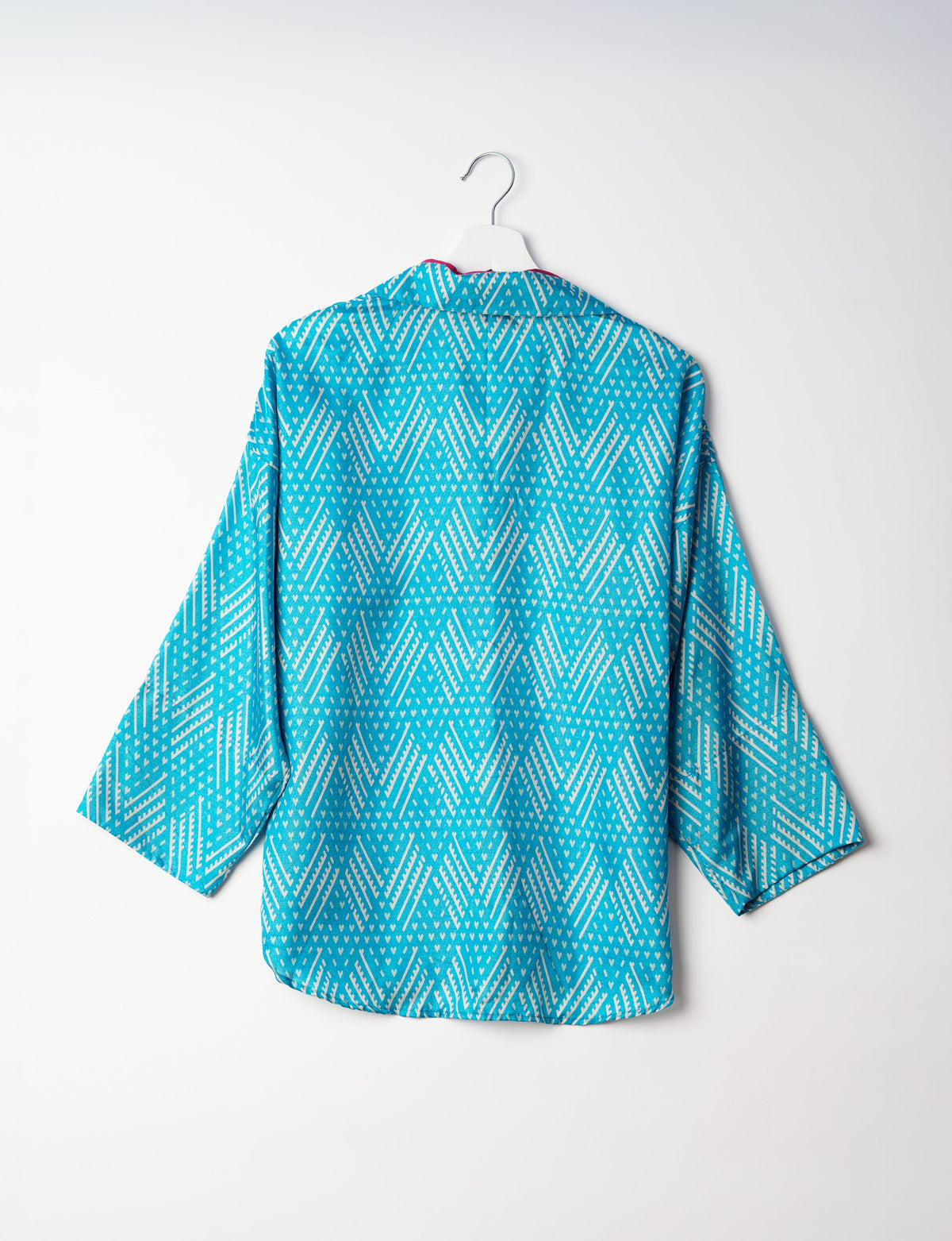 Experience chic comfort with our OVERSIZED SHIRT – a one-of-a-kind piece crafted from sari waste by talented Indian female artisans. With 3/4 length sleeves, a regular shirt collar, and a contrasting inner collar band, this shirt is perfect for work or casual hangouts. Versatile and stylish, it pairs effortlessly over a shift dress, jumpsuit, or with pants.