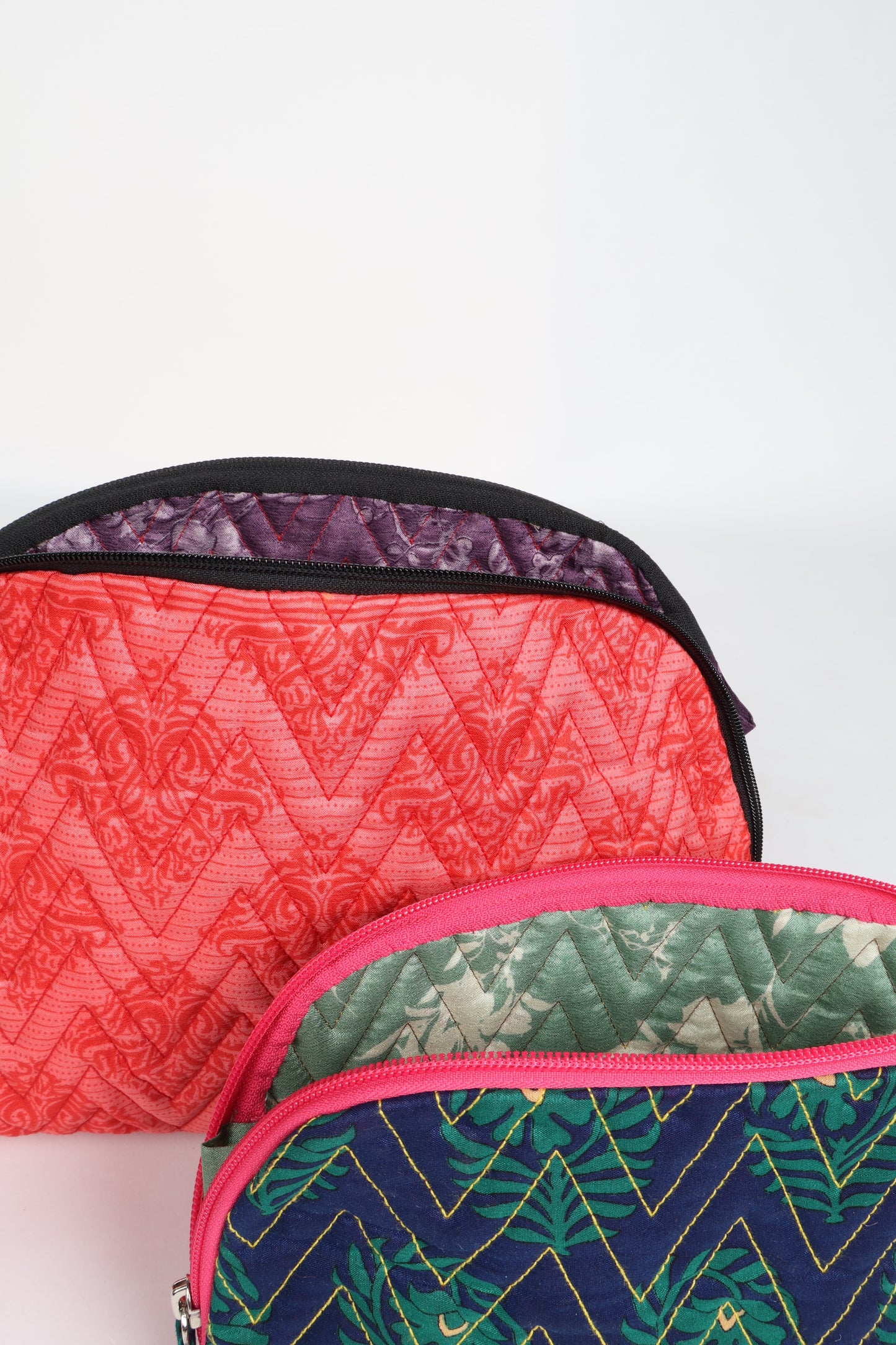 A set of two Vanity Pouches, featuring embellished beaded pullers, made from sustainable materials for eco-conscious travelers.