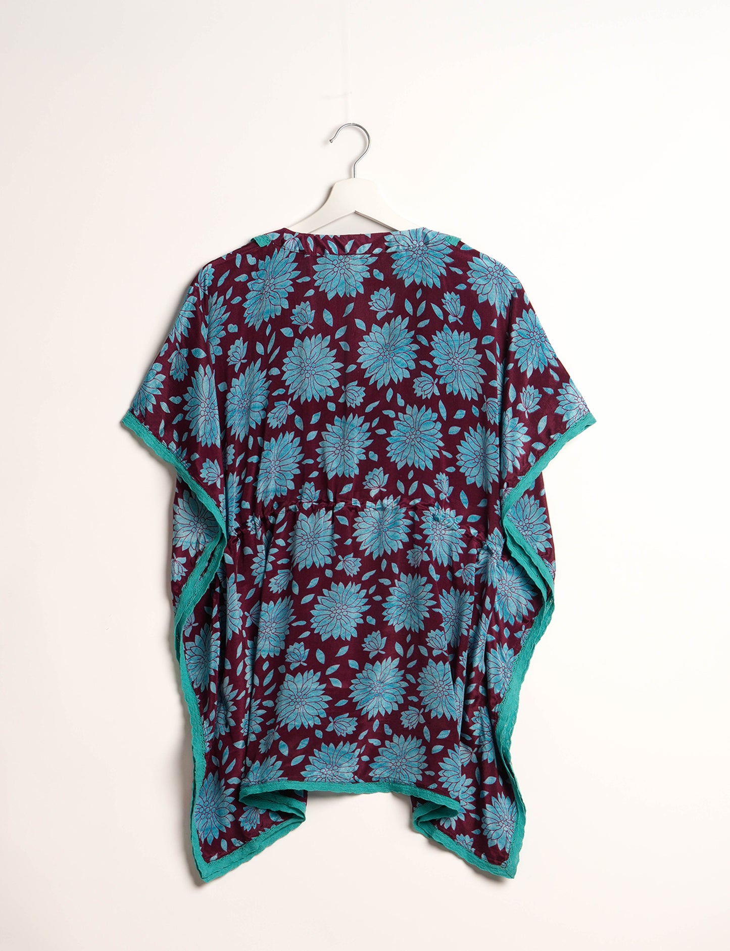 Elevate your style with our short kaftan, a perfect blend of ethical and green fashion. The light and loose-flowing fabric, drawstring waist, beaded tassel ends, and delicate lace edging make it a versatile choice for urban summers, beachwear, or poolside elegance. Enjoy sustainable and fashionable living.