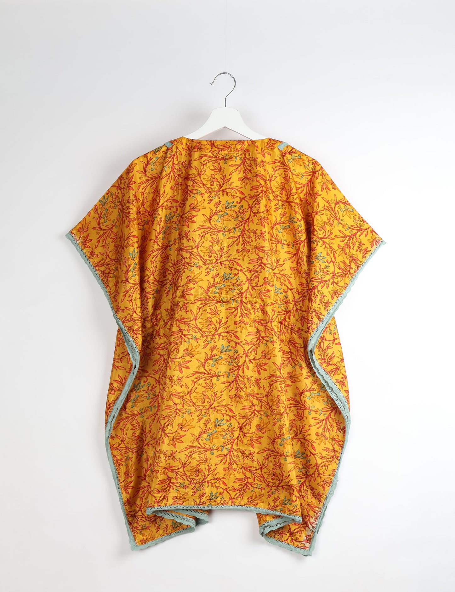 Elevate your style with our short kaftan, a perfect blend of ethical and green fashion. The light and loose-flowing fabric, drawstring waist, beaded tassel ends, and delicate lace edging make it a versatile choice for urban summers, beachwear, or poolside elegance. Enjoy sustainable and fashionable living.