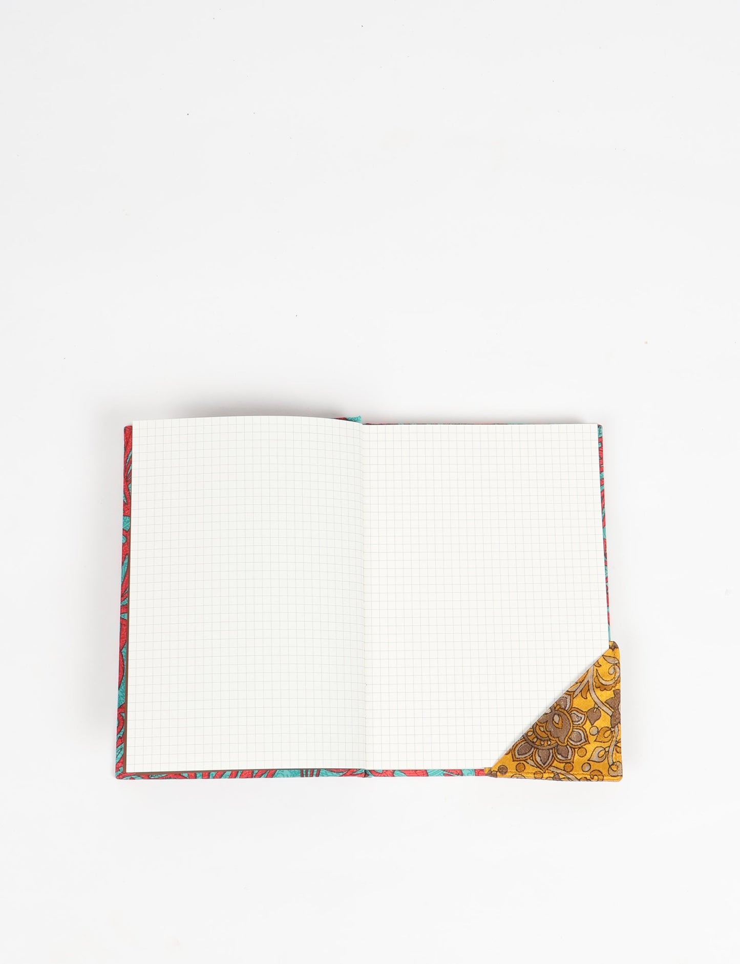 Colorful square-shaped corner bookmark made from recycled sari textiles, representing repurposed clothing, fair trade fashion, and ethical fashion. An earth-friendly product made from textile waste, aligning with carbon neutral clothing values.