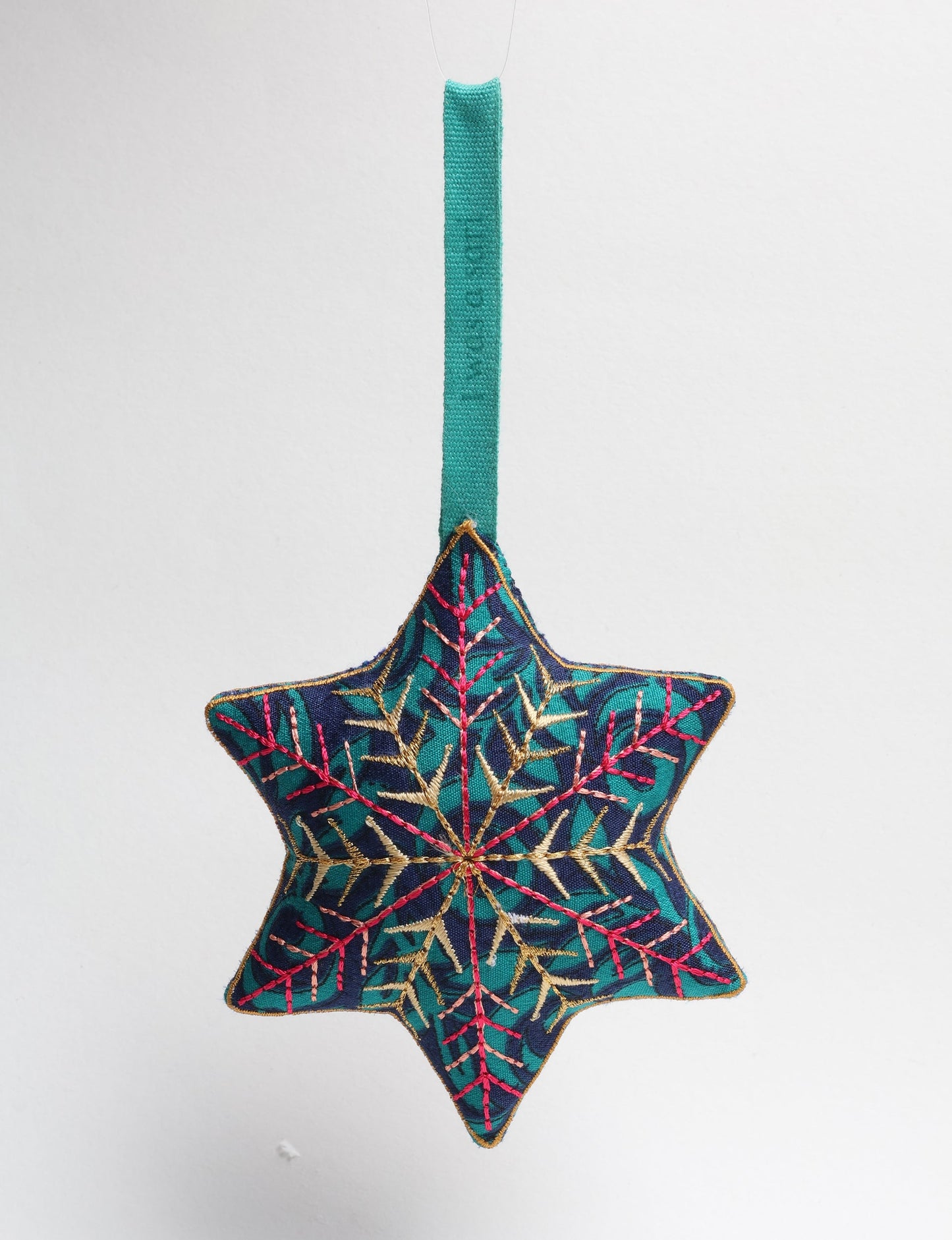 Timeless snowflake ornament made from preloved sari fabric with metallic embroidery, promoting green fashion, fair trade fashion, recycled material clothing, repurposed clothing, sustainable women's clothing, and circular fashion for a conscious lifestyle.
