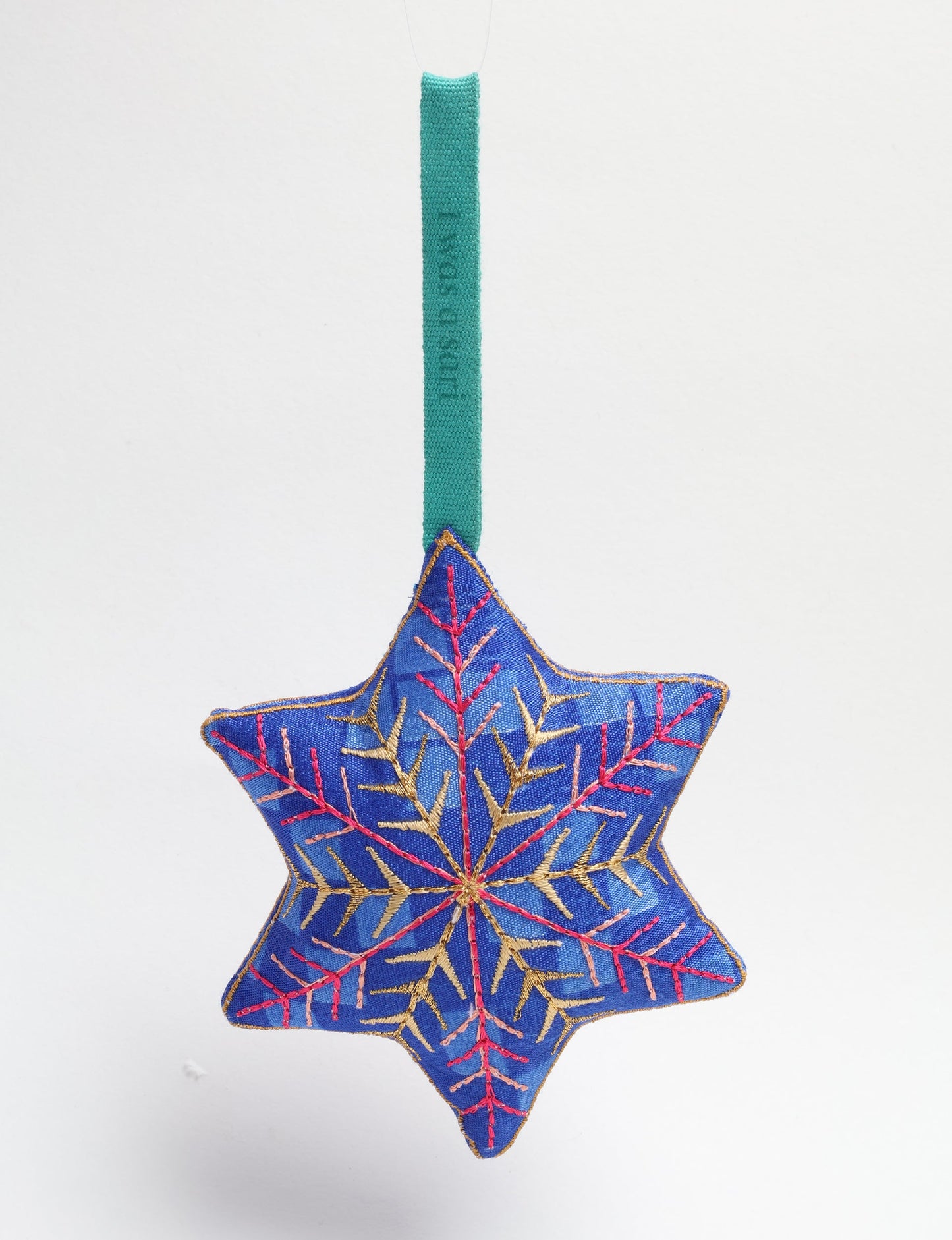 Timeless snowflake ornament made from preloved sari fabric with metallic embroidery, promoting green fashion, fair trade fashion, recycled material clothing, repurposed clothing, sustainable women's clothing, and circular fashion for a conscious lifestyle.