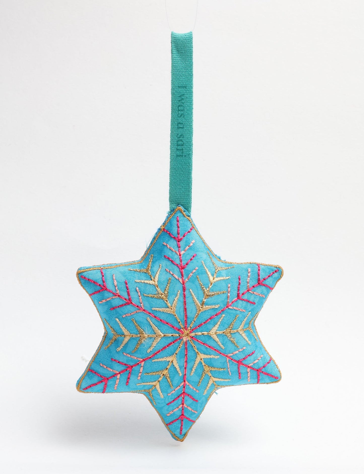 Timeless snowflake ornament made from preloved sari fabric with metallic embroidery, promoting green fashion, fair trade fashion, recycled material clothing, repurposed clothing, sustainable women's clothing, and circular fashion for a conscious lifestyle.