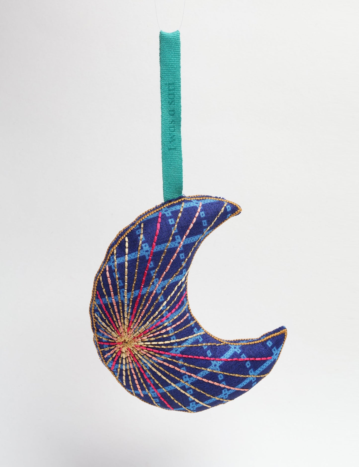 Timeless crescent moon ornament made from recycled materials and textile waste, featuring intricate embroidery. A zero waste and carbon offset accessory that supports circular fashion, fair trade fashion, and environmentally friendly clothing choices.