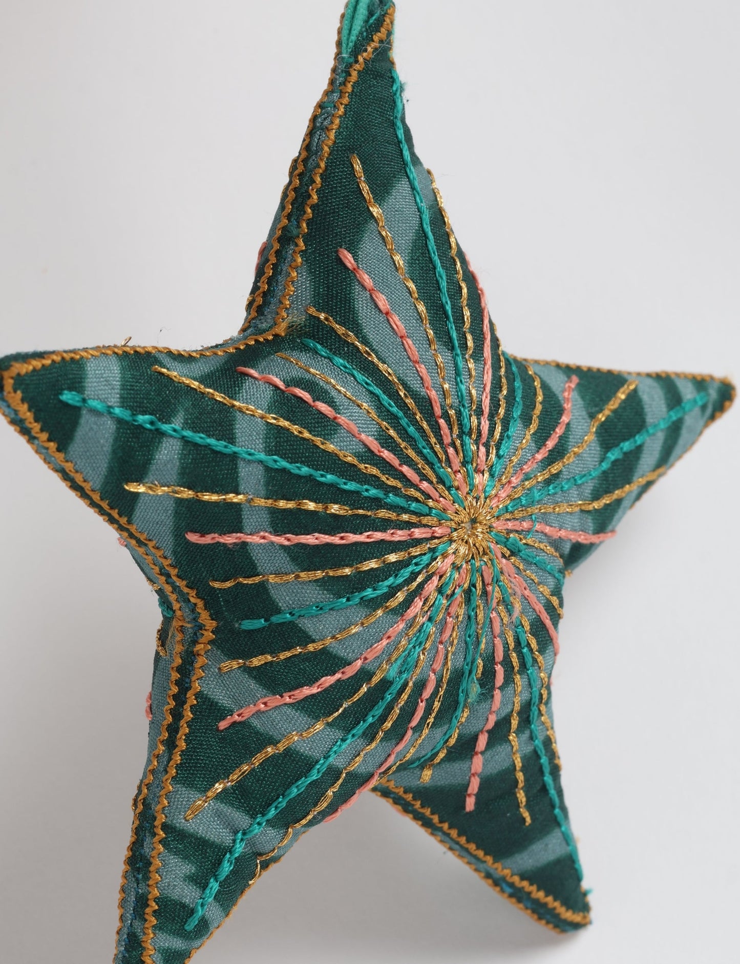 Timeless star ornament made from recycled sari fabric, featuring silk and metallic embroidery, crafted as part of green fashion, recycled clothing design, environmentally friendly clothing practices, and repurposed clothing traditions.