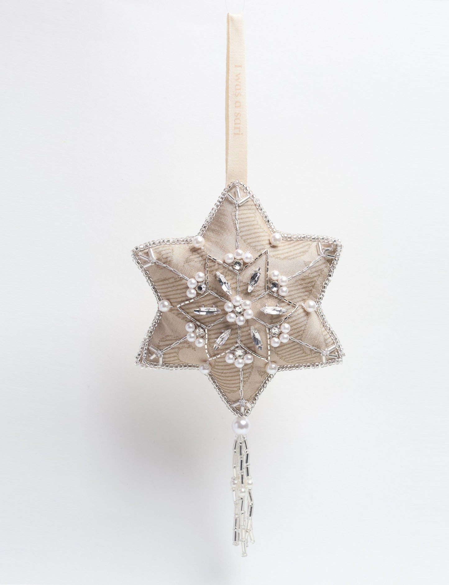 Silver snowflake ornament made from ivory and grey recycled sari products, enhanced with silver beads and pearls. Designed for lovers of eco friendly products, climate neutral clothing, and repurposed clothing, supporting zero waste clothing and conscious clothing movements.