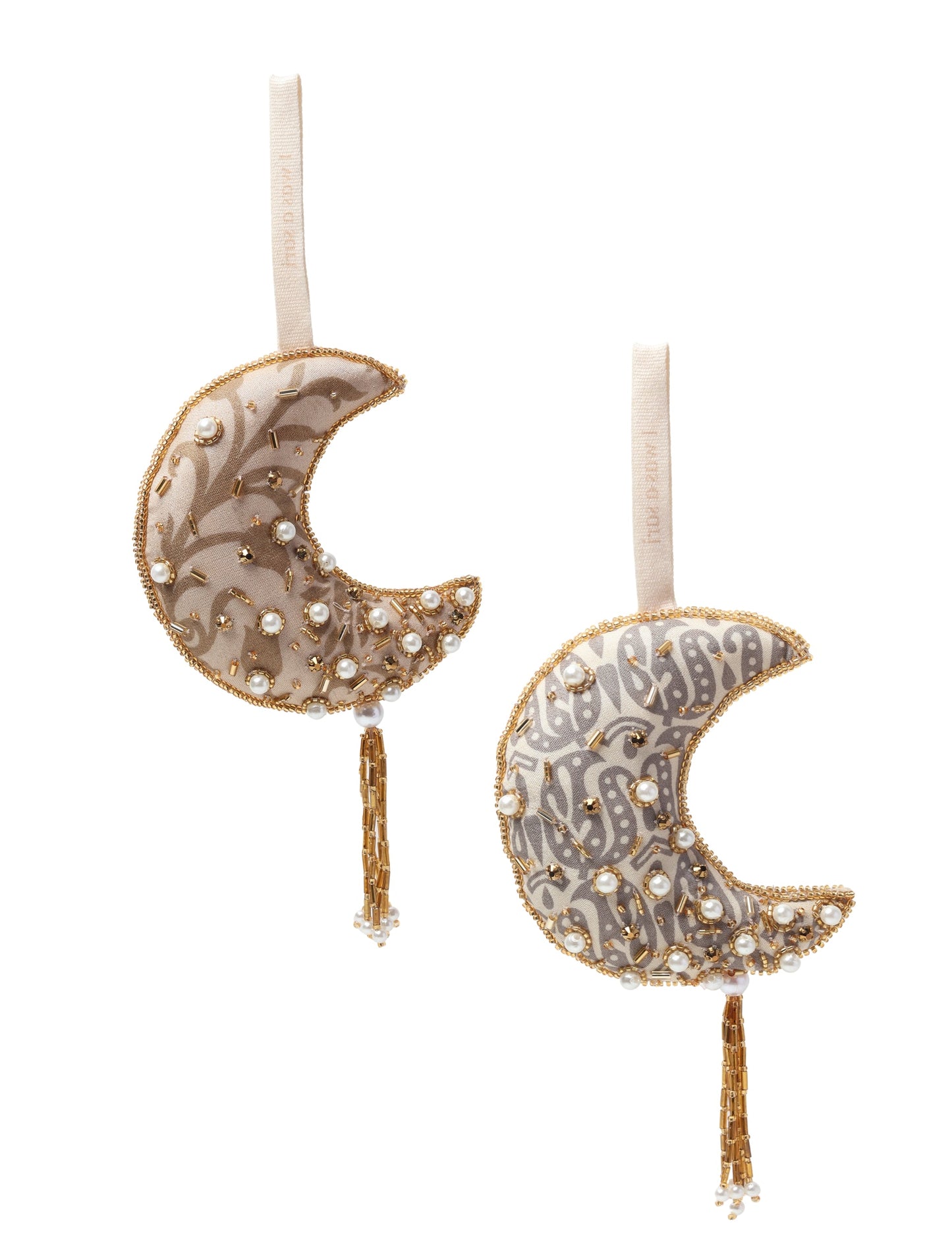 A crescent moon ornament made from ivory and cream recycled fabric, filled with organic cotton, embellished with gold stones and beads. This recycled clothing piece aligns with circular fashion, earth friendly clothing, and fashion revolution ideals, crafted to support repurposed clothing and eco friendly fashion.