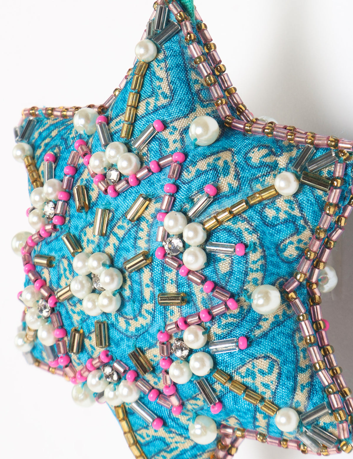 Teal fabric star-shaped snowflake ornament with bead and pearl embellishments, hanging by a teal fabric loop