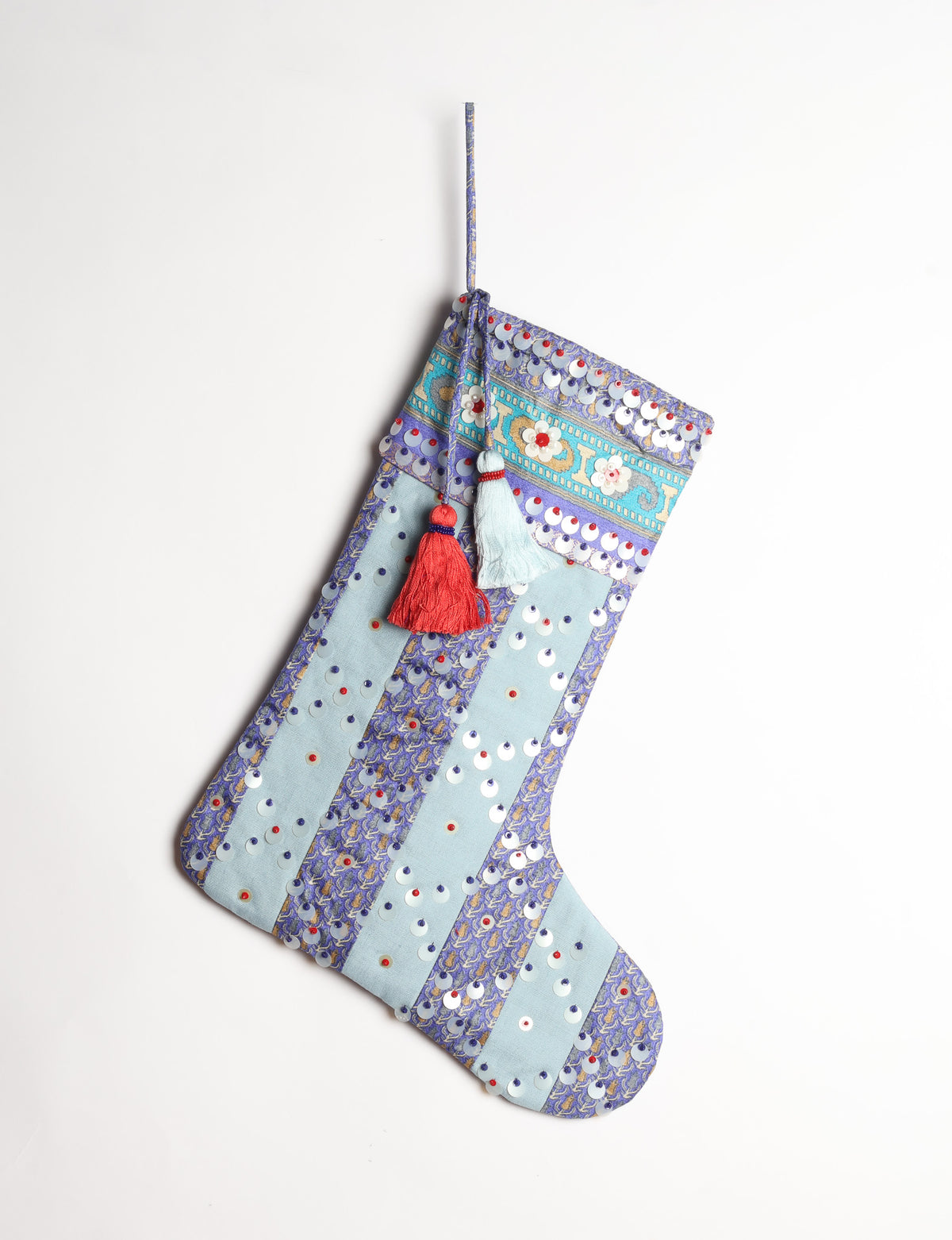 Upcycled sari Christmas stocking with striped cotton accents and hand-embroidered embellishments, reflecting green fashion, zero-waste clothing, recycled fashion, repurposed clothing, carbon-neutral fashion, natural clothing, conscious clothing, and sustainable women’s clothing.
