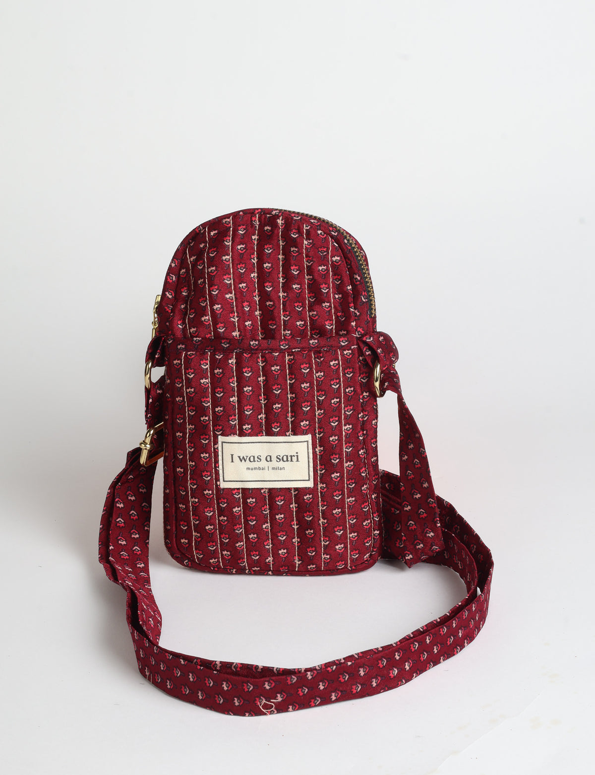 Compact quilted mobile bag featuring a padded rectangular silhouette, secure zip-top closure and adjustable crossbody strap for everyday use.