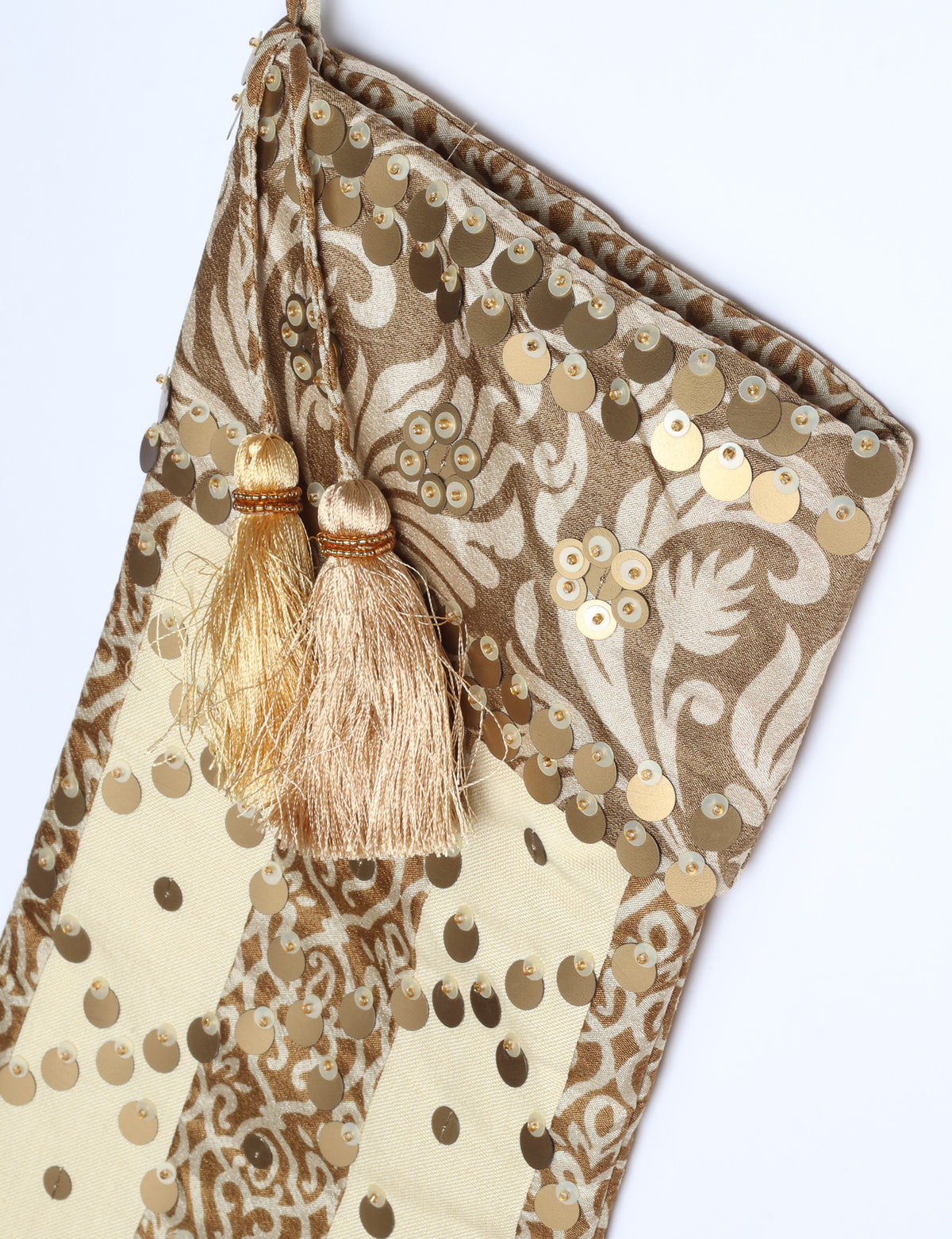 Christmas stocking with beige and brown floral and stripe pattern, gold sequins, and two beige tassels on hanging loop
