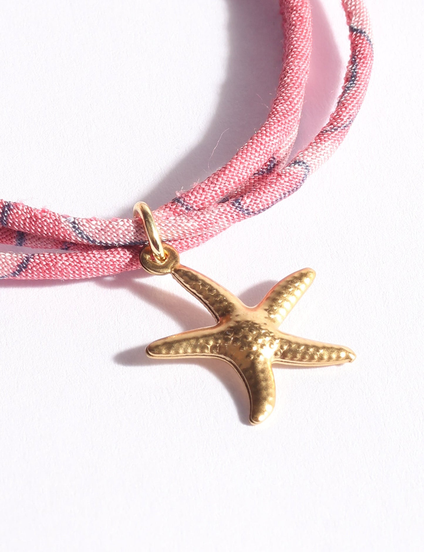 Slim adjustable cord bracelet with gold-plated stainless steel star fish charm inspired by upcycled women’s clothing, sustainable women’s clothing, eco friendly clothes, recycled sustainable fashion, carbon neutral clothing, and environment friendly clothing values.