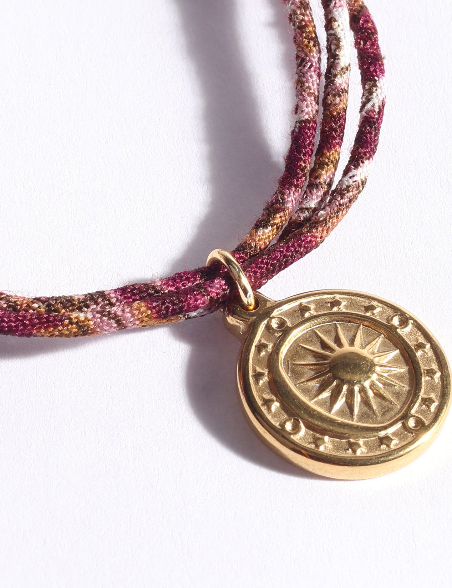 Slim adjustable cord bracelet with gold-plated stainless steel sun charm, inspired by upcycled women’s clothing, sustainable women’s clothing, eco friendly fashion, recycled sustainable fashion, carbon neutral fashion, and environment friendly clothing values.