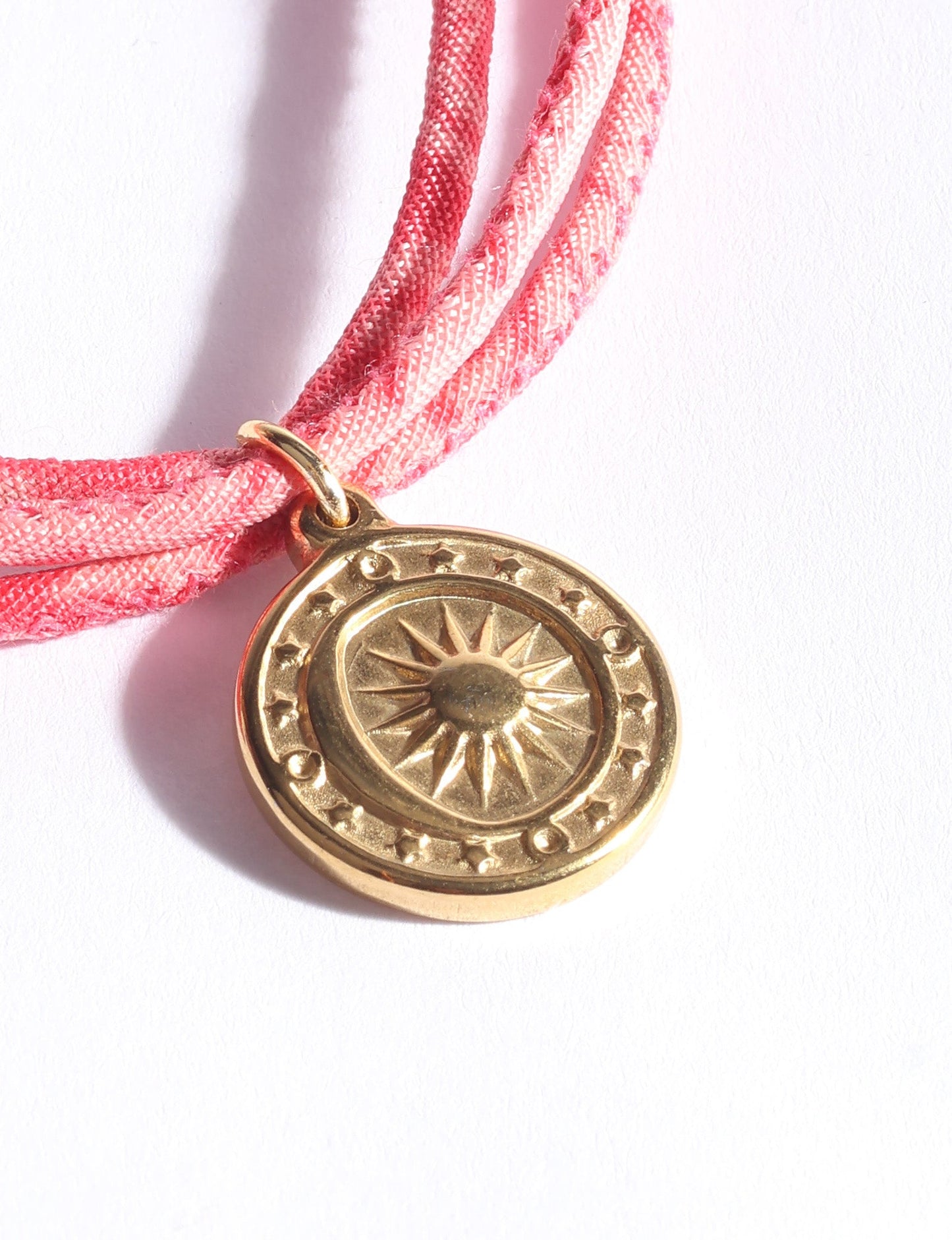 Slim adjustable cord bracelet with gold-plated stainless steel sun charm, inspired by upcycled women’s clothing, sustainable women’s clothing, eco friendly fashion, recycled sustainable fashion, carbon neutral fashion, and environment friendly clothing values.