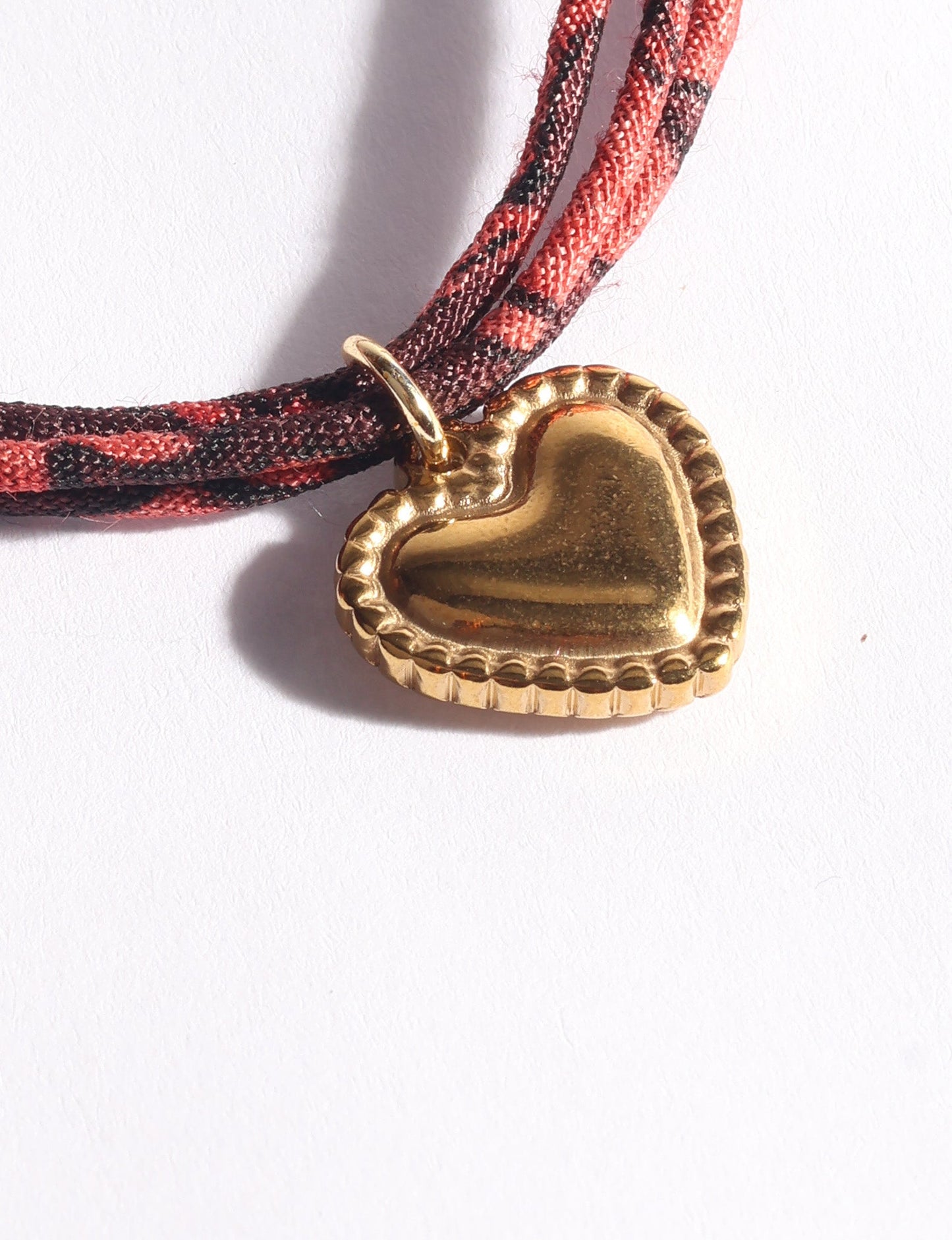 Slim adjustable cord bracelet with gold-plated stainless steel heart charm inspired by upcycled women’s clothing, sustainable women’s clothing, eco friendly fashion, recycled sustainable fashion, carbon neutral fashion, and environment friendly clothes values.