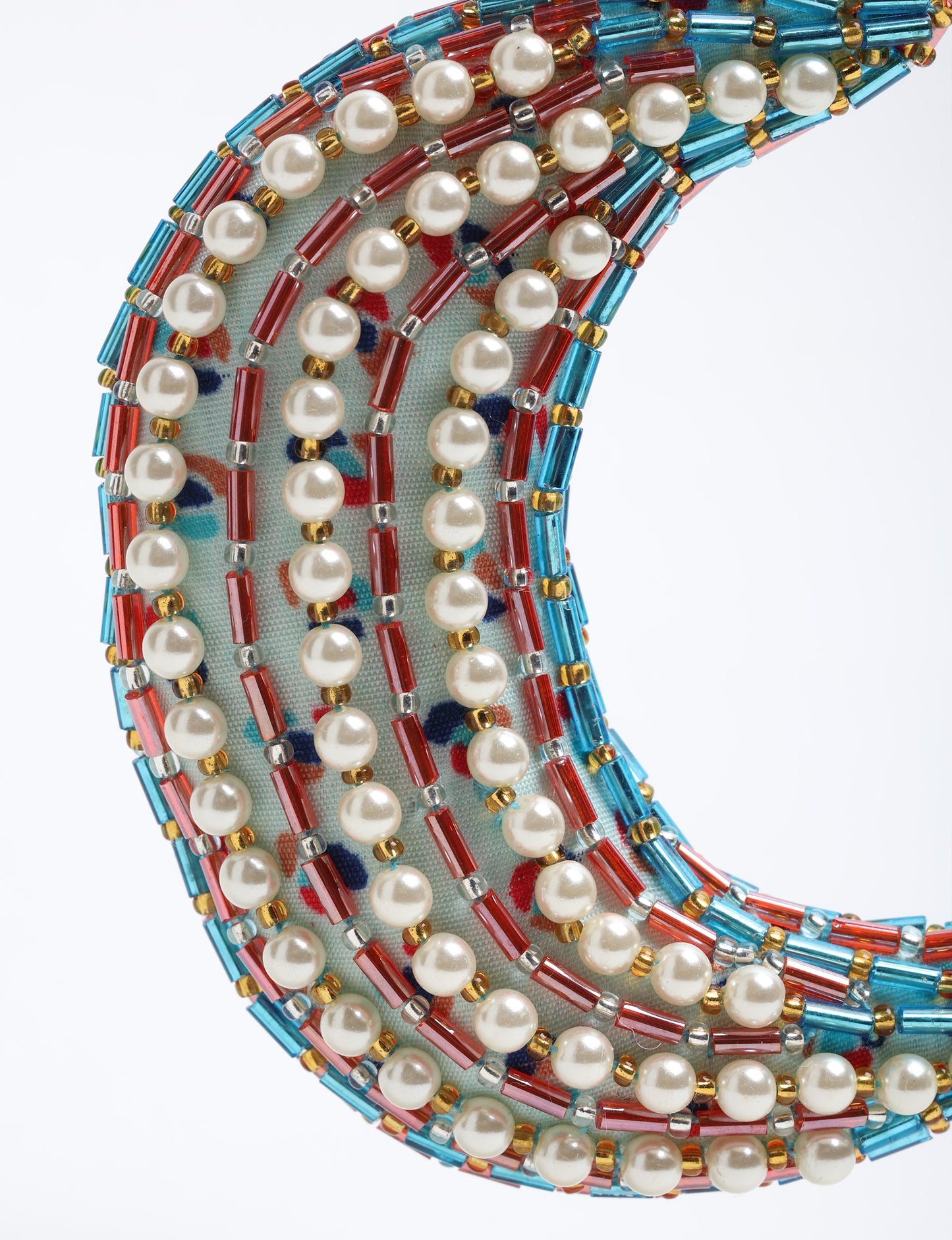 Handcrafted crescent moon-shaped Christmas ornament made from recycled sari fabric, featuring pearls and metallic bead embroidery. A beautiful example of upcycled clothing and fair trade fashion, created through environmentally friendly clothing practices and carbon neutral fashion design.