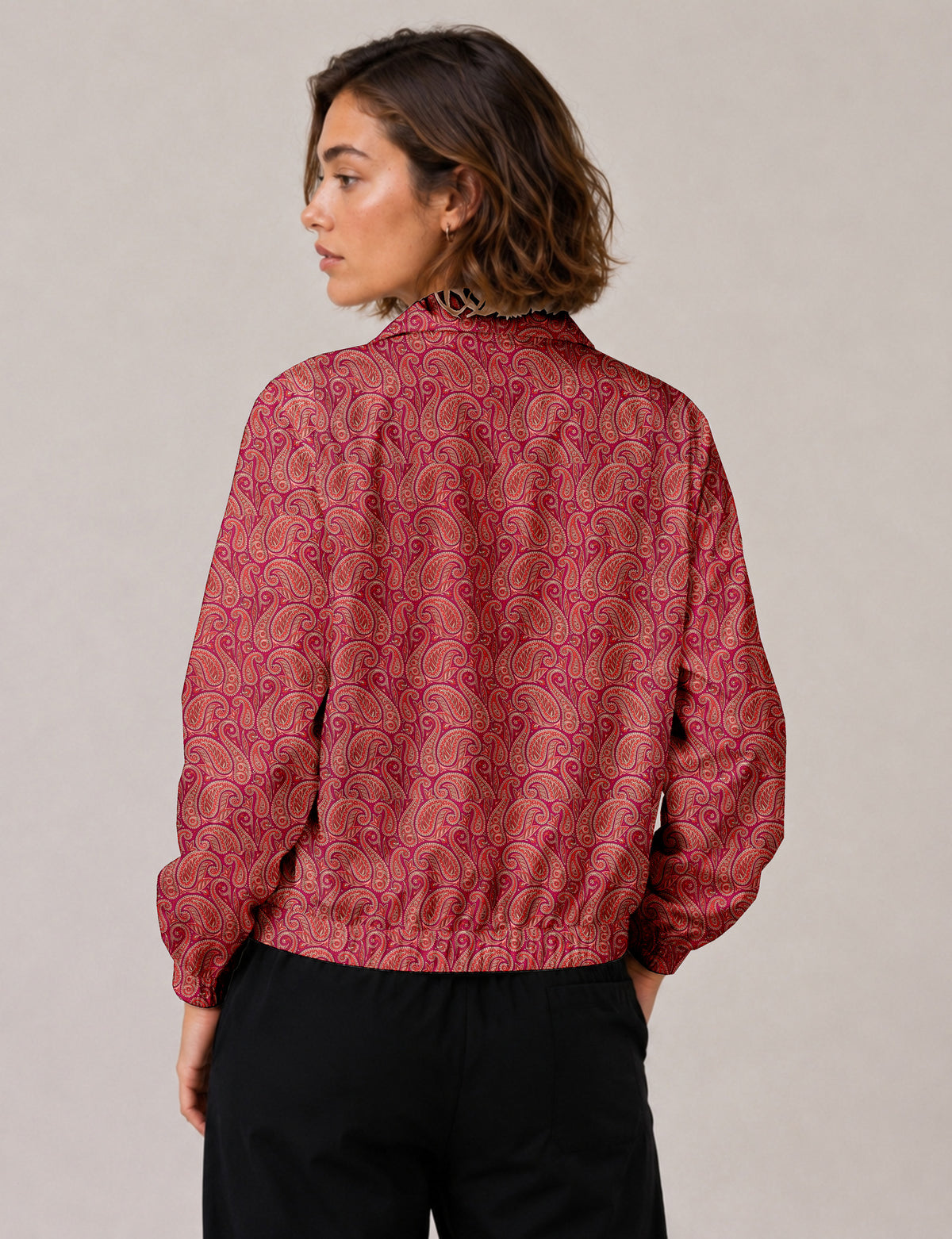 Woman wearing a yellow floral bomber jacket with front zipper, elastic cuffs, and side pockets, shown from front view