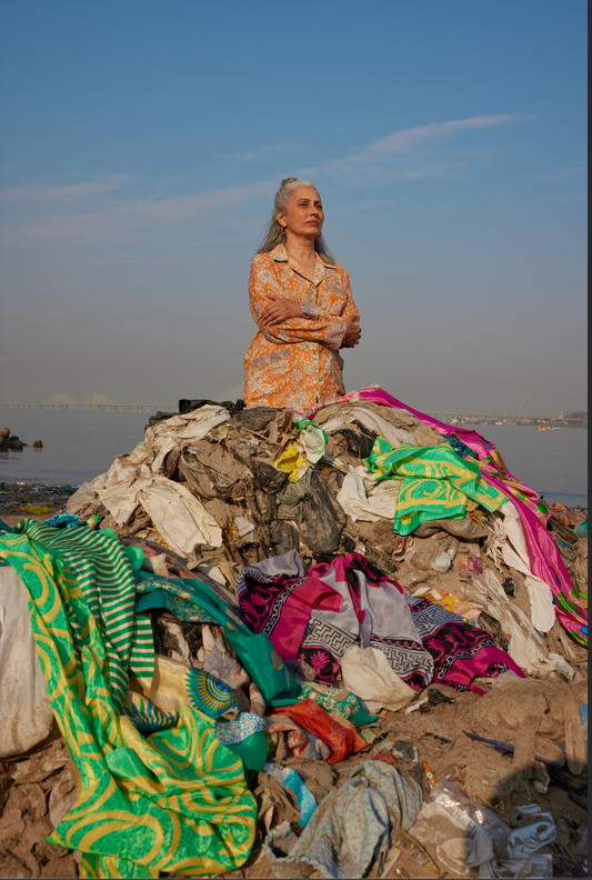 woman wearing I was a Sari clothing standing near a big pile of textile waste