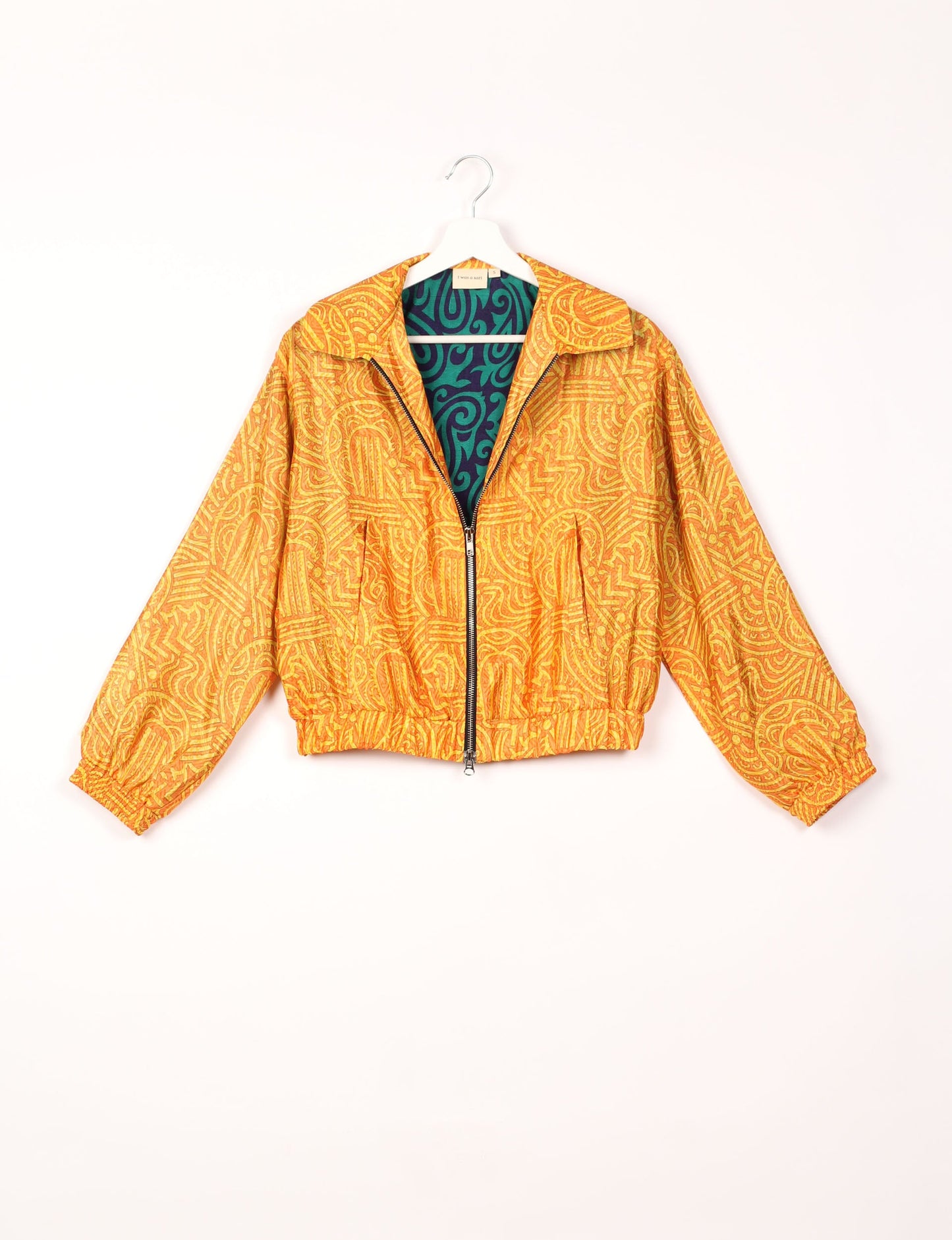 Stylish BOMBER JACKET, an upcycled clothing masterpiece with a cute cropped shape, elasticated details, and detachable metallic zipper. Contrast sari print lining adds a unique touch. Explore sustainable and eco-friendly fashion.