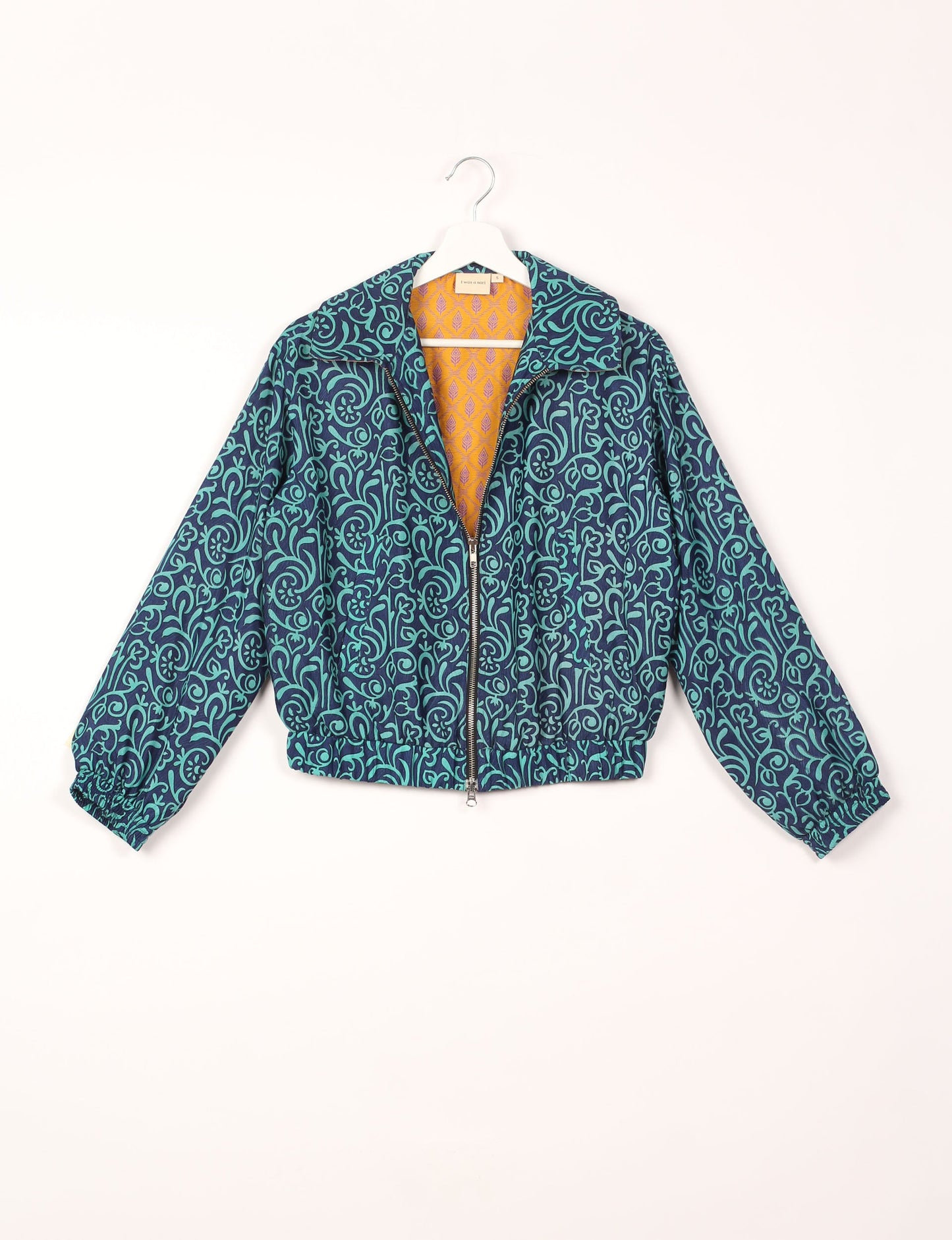 Stylish BOMBER JACKET, an upcycled clothing masterpiece with a cute cropped shape, elasticated details, and detachable metallic zipper. Contrast sari print lining adds a unique touch. Explore sustainable and eco-friendly fashion.