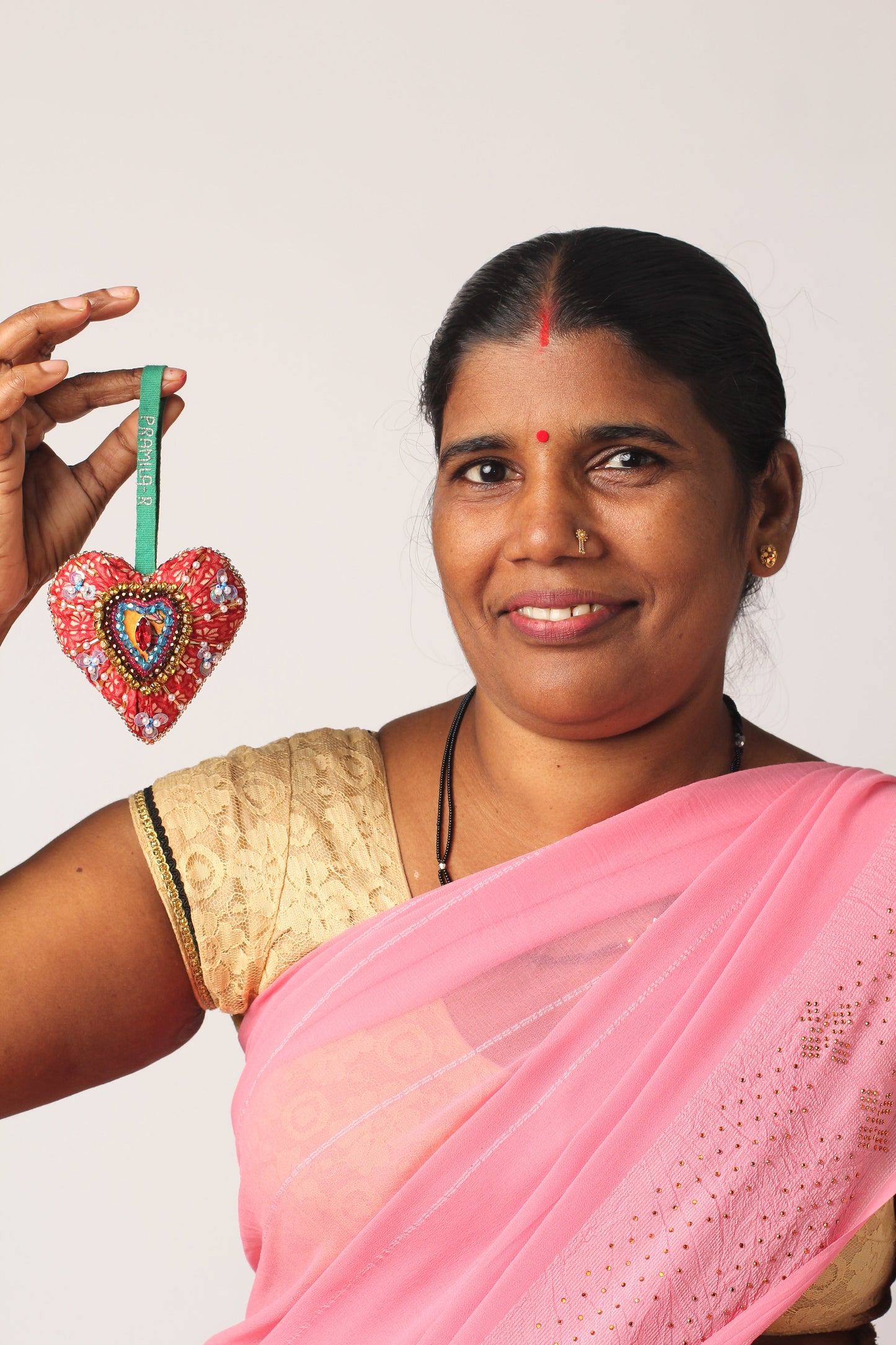 Heart-shaped Artisans Christmas Ornament crafted from upcycled saris with intricate design, symbolizing love and kindness. An eco-friendly, sustainable fashion piece that supports ethical, zero-waste, and recycled clothing ideals.