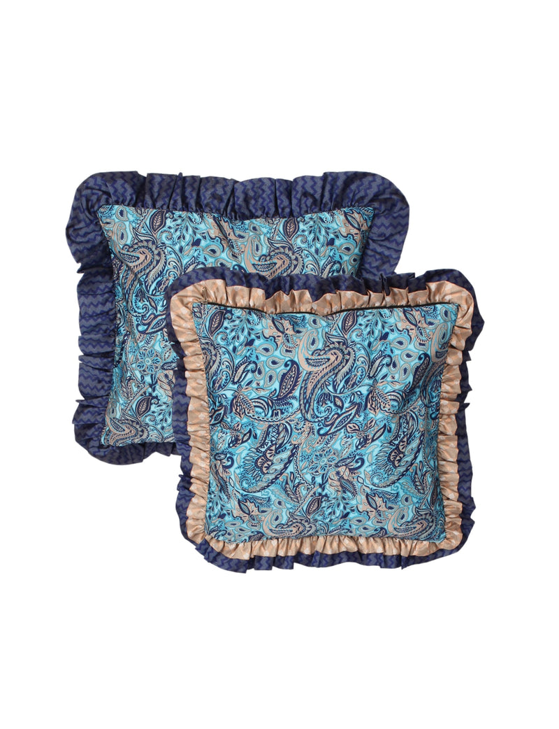 Set of two blue tropical cushion covers with double frill edges, paisley pattern, and contrasting ruffle trim, flat lay view