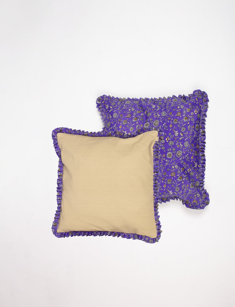 Set of two cushion covers with purple floral frill edges, one solid beige front and one purple floral pattern, flat lay