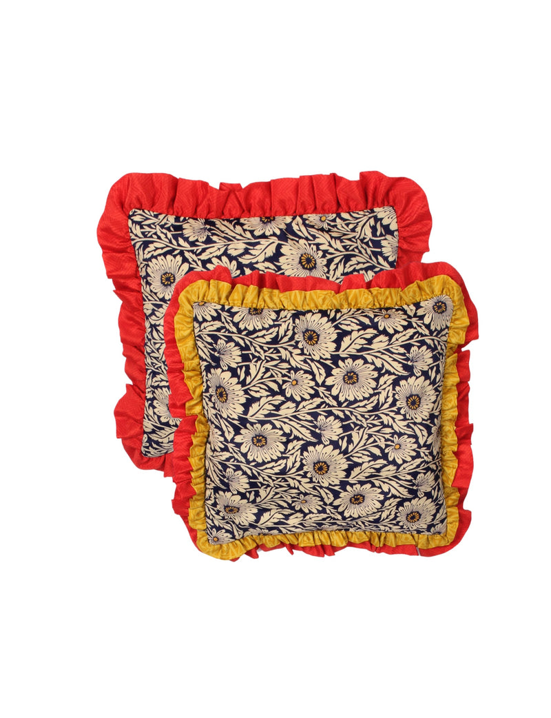 Set of two floral cushion covers with double frill edges in red and yellow, navy blue background with cream flowers, flat lay