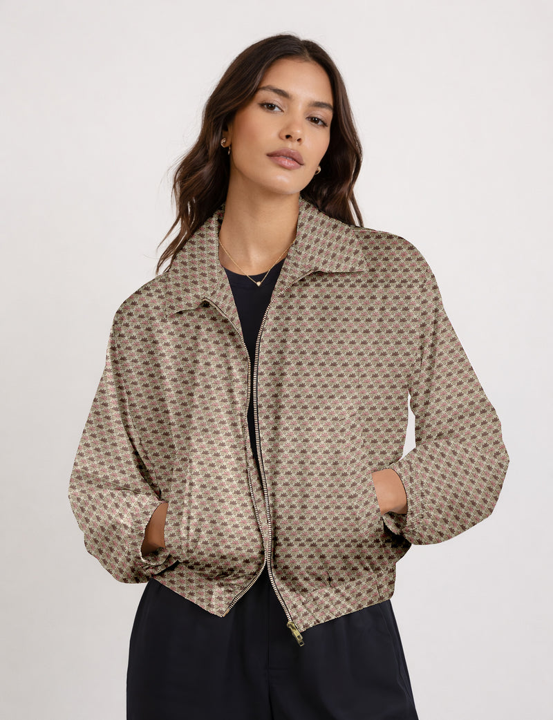 Brown floral bomber jacket with front zipper, elastic cuffs and hem, hanging on white hanger, red floral inner lining visible